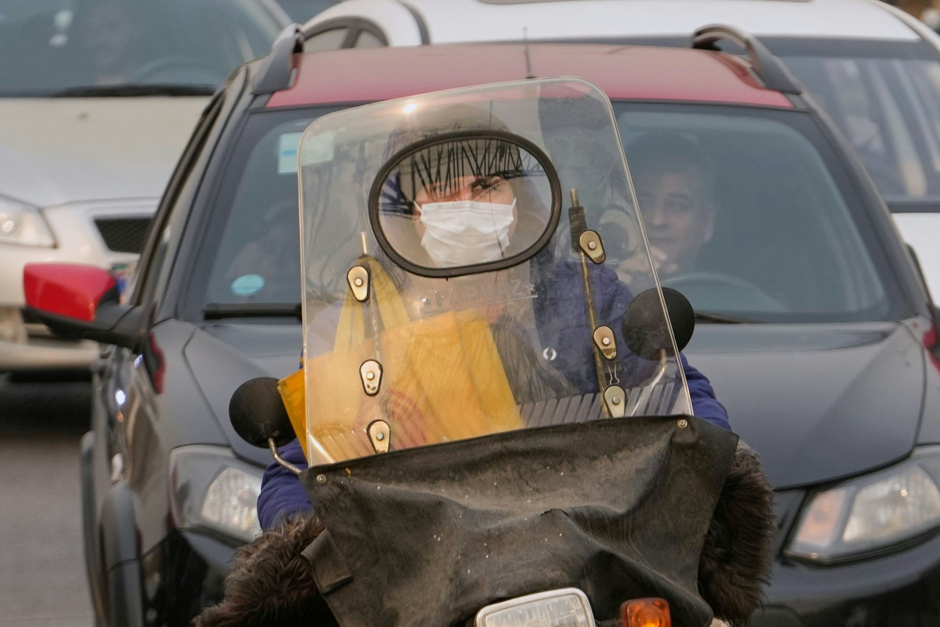 Ein Mann fährt mit seinem Motorrad, während er bei hoher Luftverschmutzung in Teheran eine Gesichtsmaske trägt. Auch Frauen dürfen künftig im Iran einen Motorradführerschein machen.