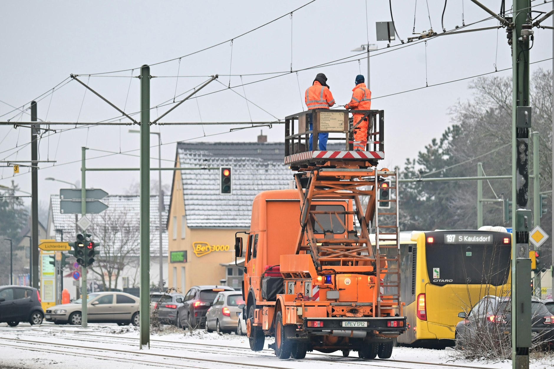 Von einem Turmwagen aus versuchen BVG-Mitarbeitwer, Oberleitungen der Straßenbahn von der Eissschicht zu befreien.