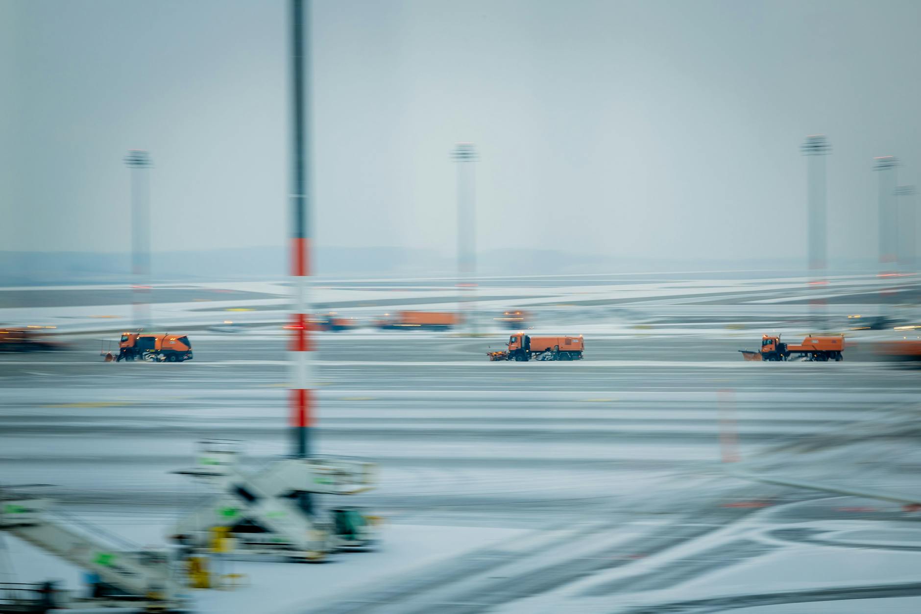 Räumfahrzeuge sind am Hauptstadtflughafen BER am Boden im Einsatz. Aber in die Luft geht am Donnerstagabend niemand mehr. Der Flugverkehr ist aufgrund der Witterung eingestellt worden.