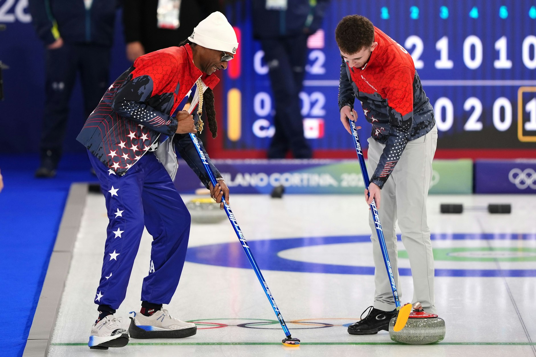 Der US-amerikanische Rapper Snoop Dogg übt mit dem Curling-Team der USA und lässt sich von Daniel Casper zeigen, wie es geht.