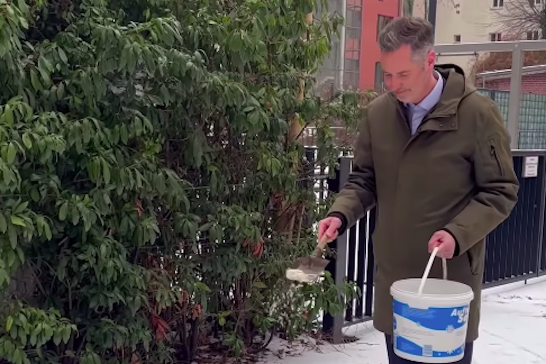Christian Dürr greift selbst zum Streusalz und streut vor der FDP-Zentrale in Berlin-Mitte