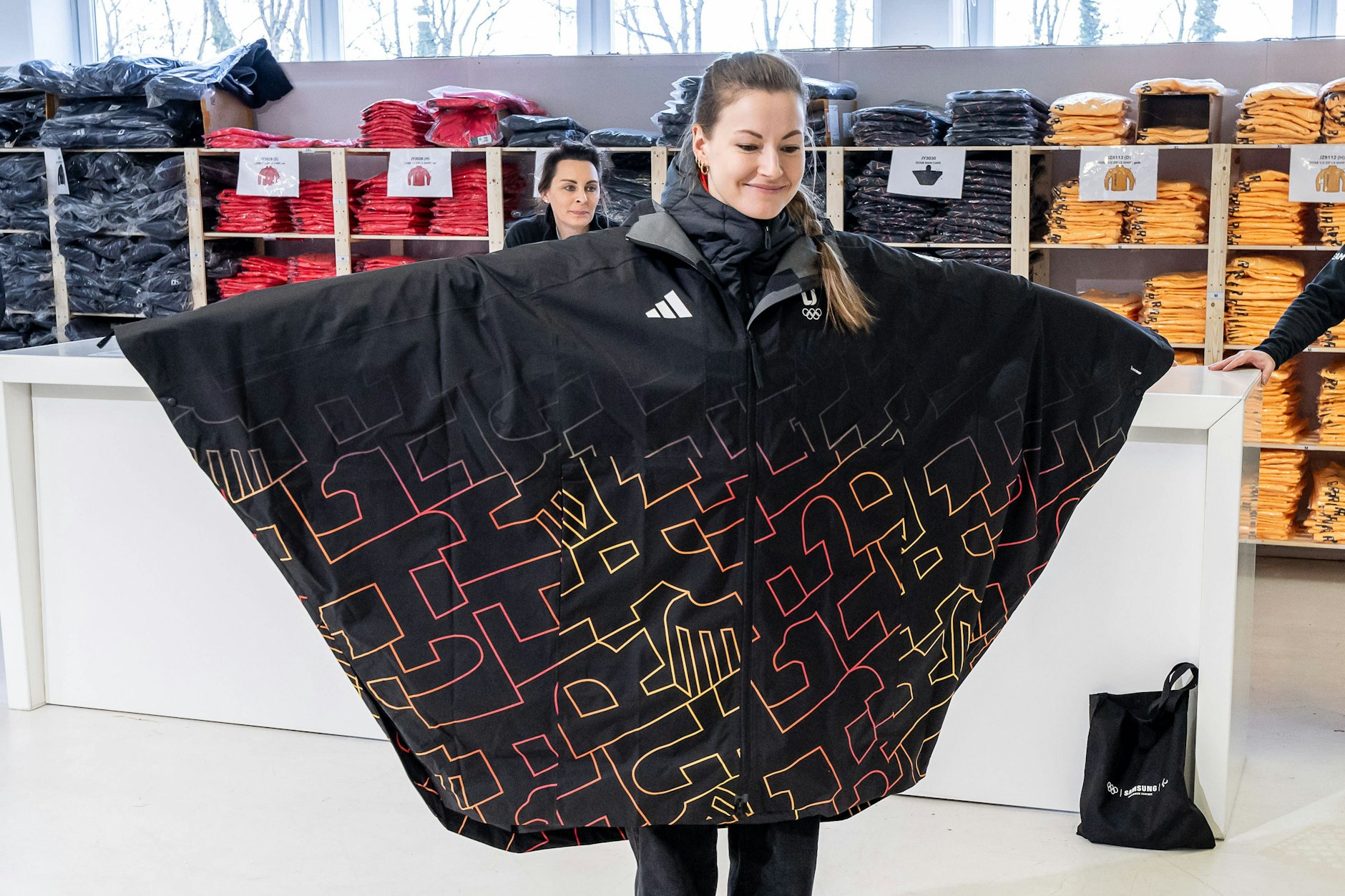 Ski-Star Johanna Holzmann betrachet sich bei der Anprobe im Spiegel. Begeisterung sieht anders aus ... Auch viele KURIER-Leser können den deutschen Ponchos nichts abgewinnen.