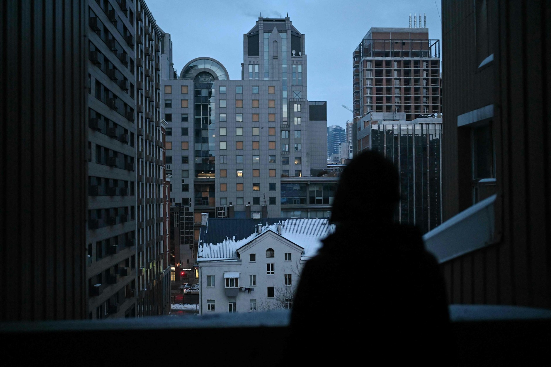 Frau blickt von ihrem Balkon auf Kiew