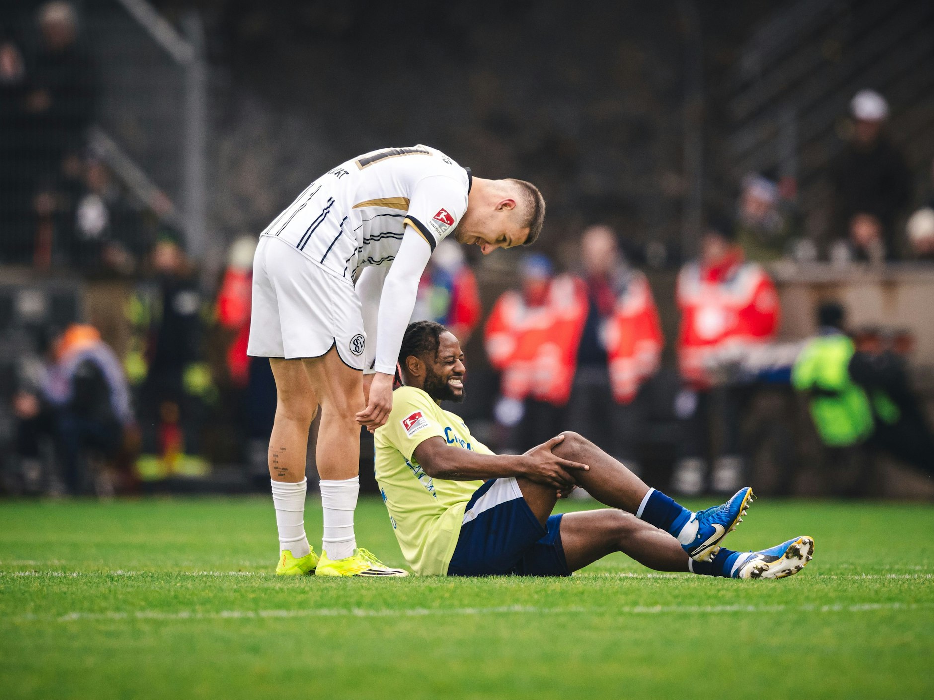 Deyovaisio Zeefuik von Hertha BSC liegt verletzt am Boden und fasst sich an sein rechtes Knie.