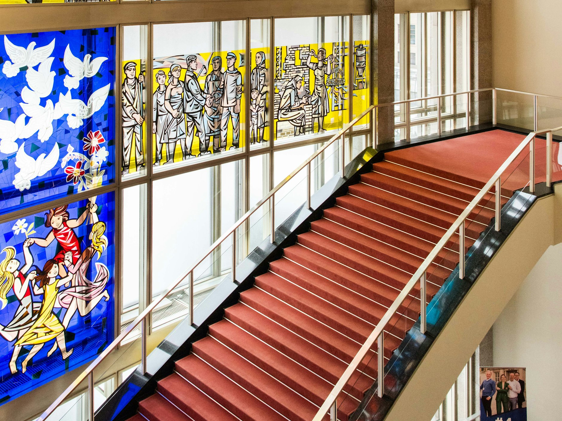 Foyertreppe mit einem Ausschnitt von Walter Womackas Glasbild „Aus der Geschichte der deutschen Arbeiterbewegung“, 2012 saniert.
