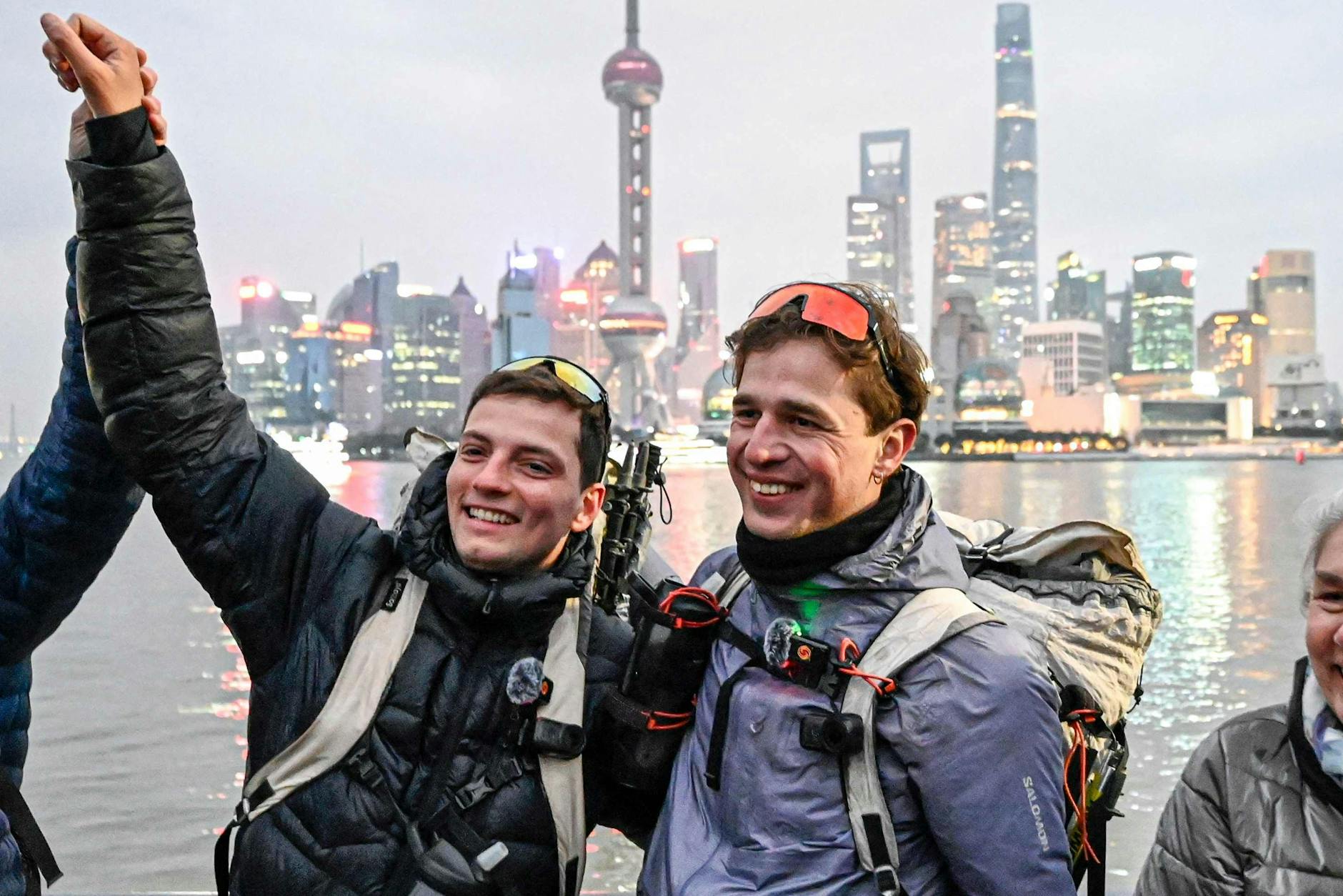 Loïc Voisot (M.r.) und Benjamin Humblot (M.l.) feiern ihre Wanderung mit ihren Familien in Shanghai.