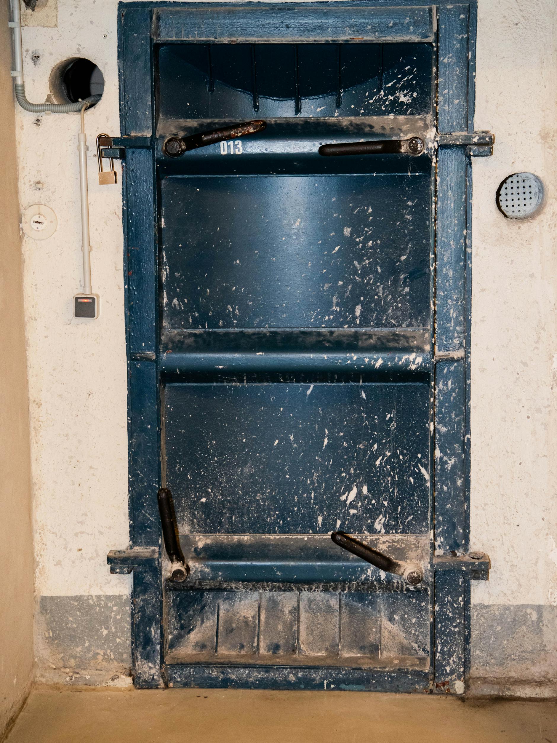 Die bei Arbeiten hinter einer Mauer entdeckte schwere Stahltür im Keller führt zu geheimnisvollen Bunkerräumen.