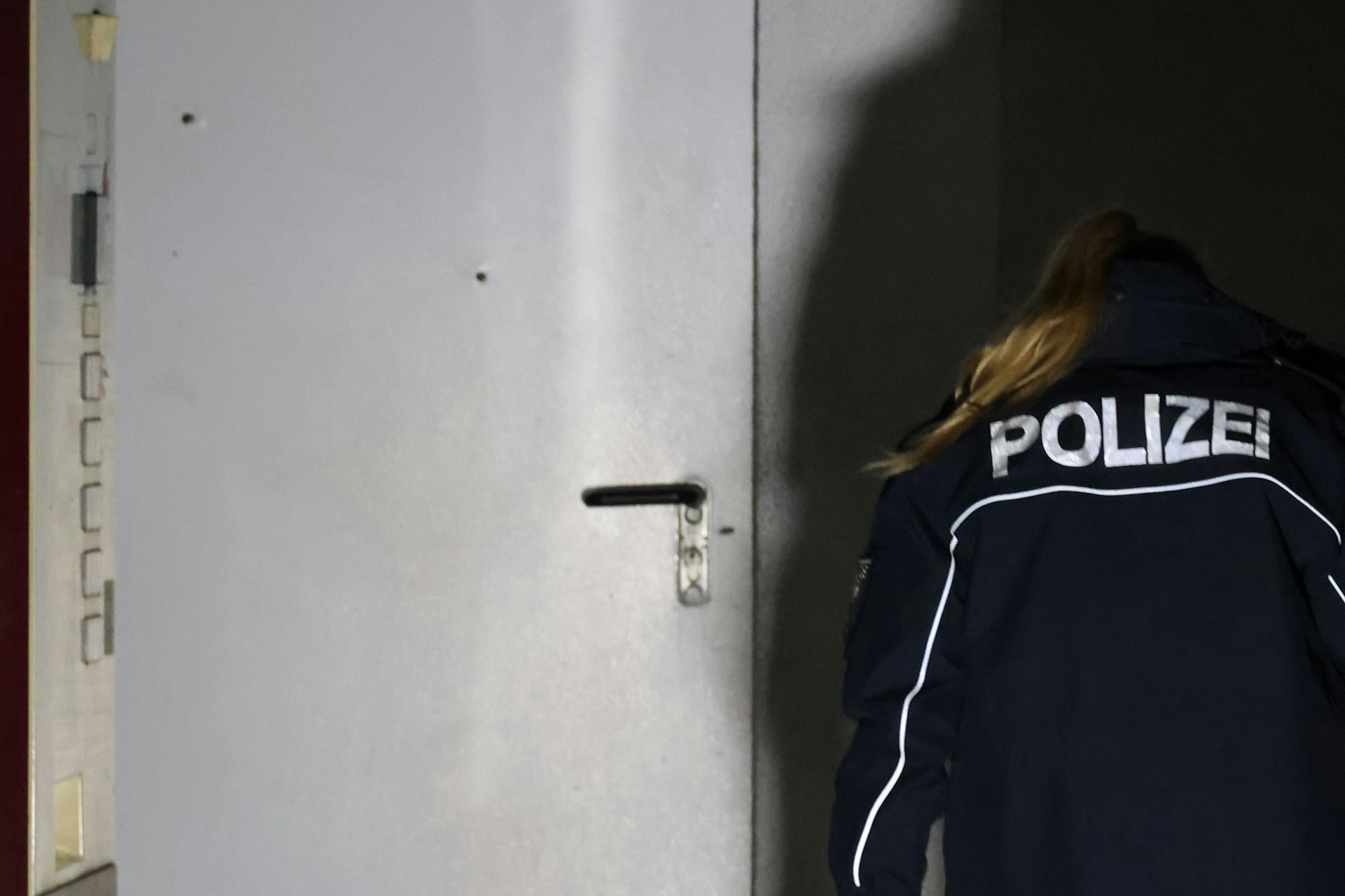 Auf dem Foto sieht man zwei Einschusslöcher (oben links) in der Eingangstür der Autowerkstatt.