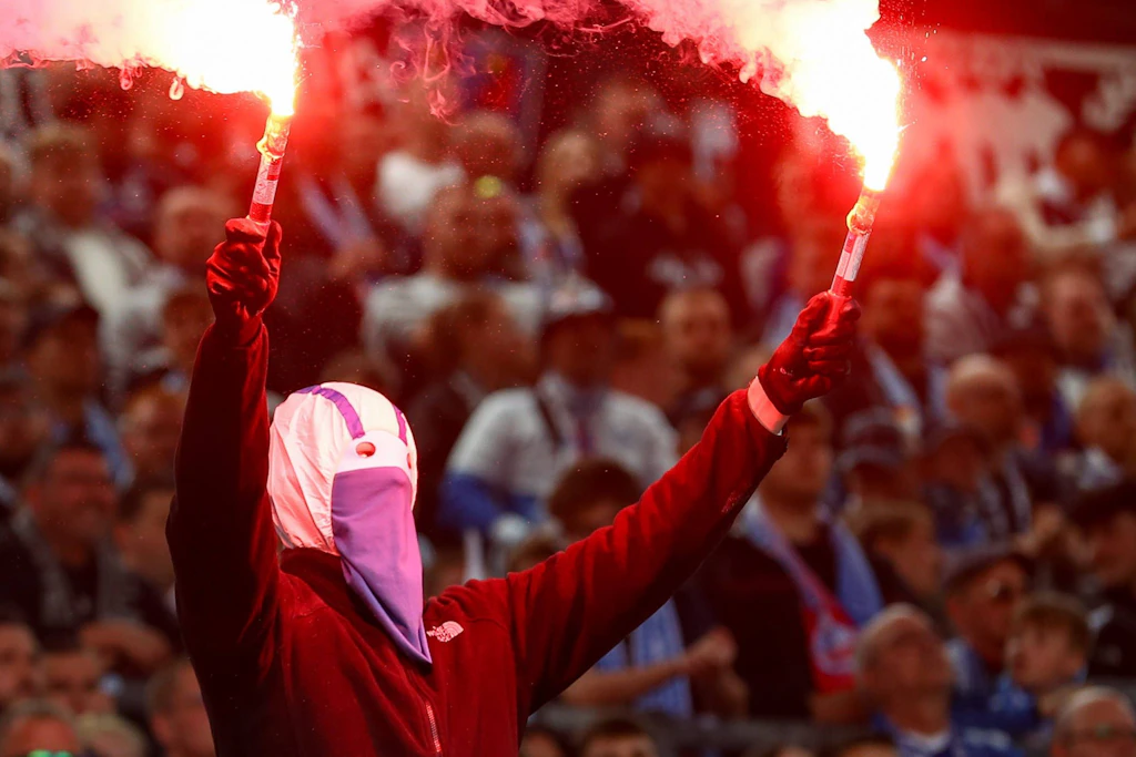 Anhänger von Hansa Rostock zündet ein Bengalo: Die Fans sind ganz wortwörtlich Feuer und Flamme.