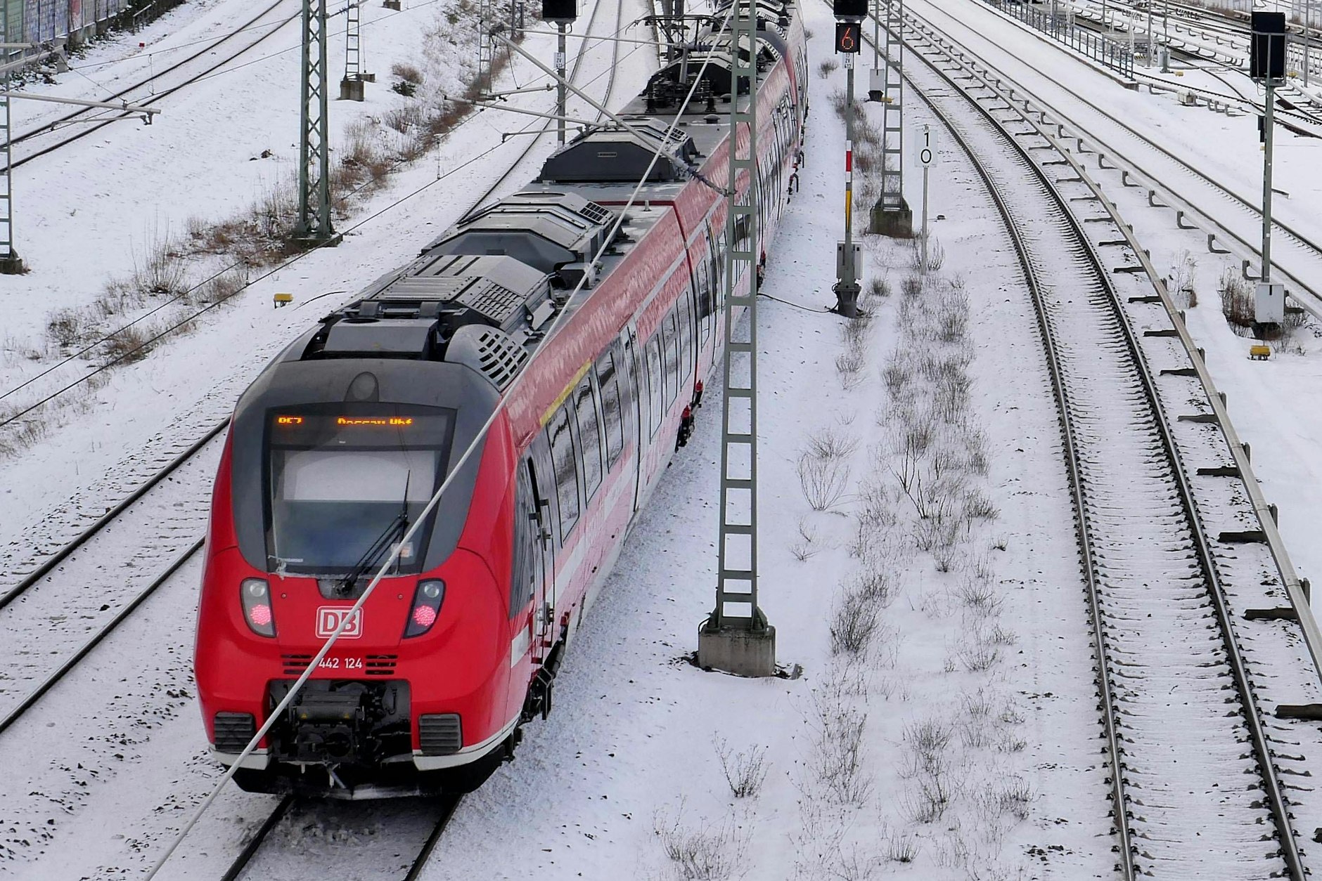 Ein Regionalzug fährt durch das verschneite Berliner Bahnnetz.