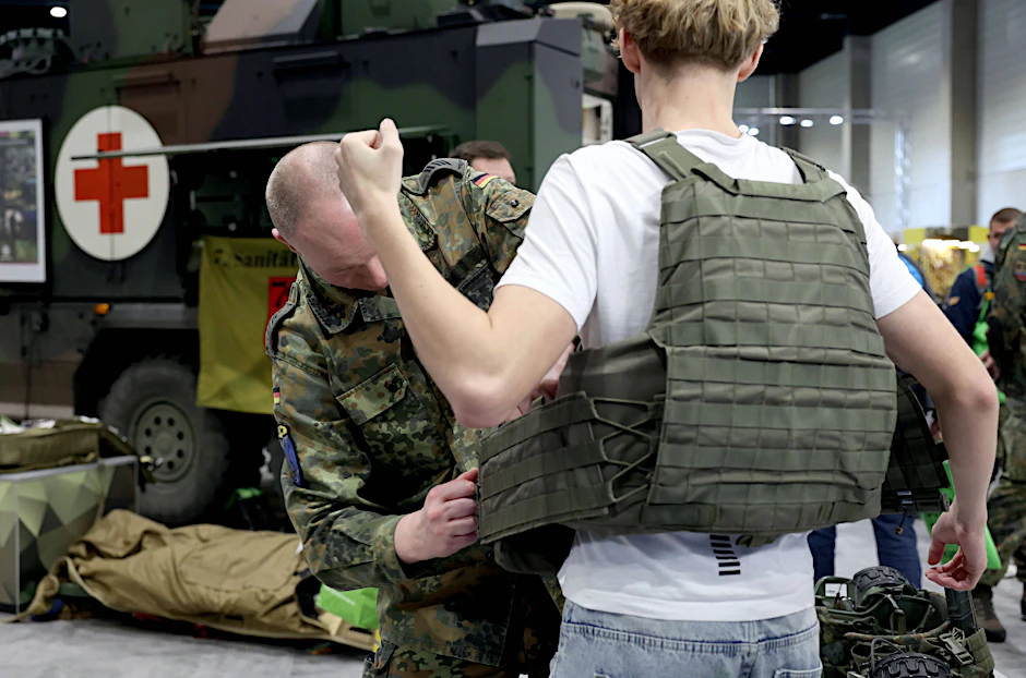 Auf der Grünen Woche in Berlin&nbsp; zeigt sich die Bundeswehr volksnah. Besucher probieren Helme und Schutzwesten an.