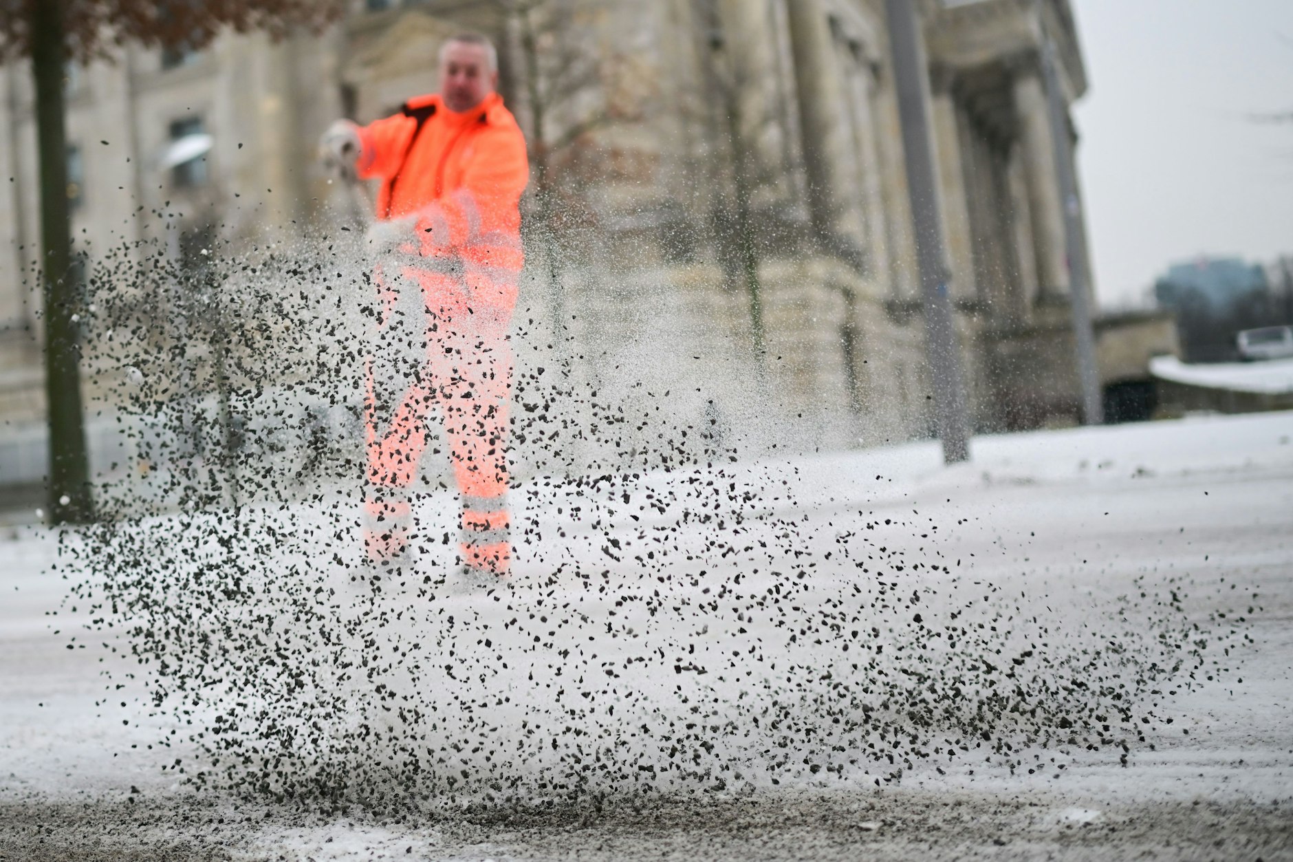 Ein Mitarbeiter der BSR streut am Reichstag.