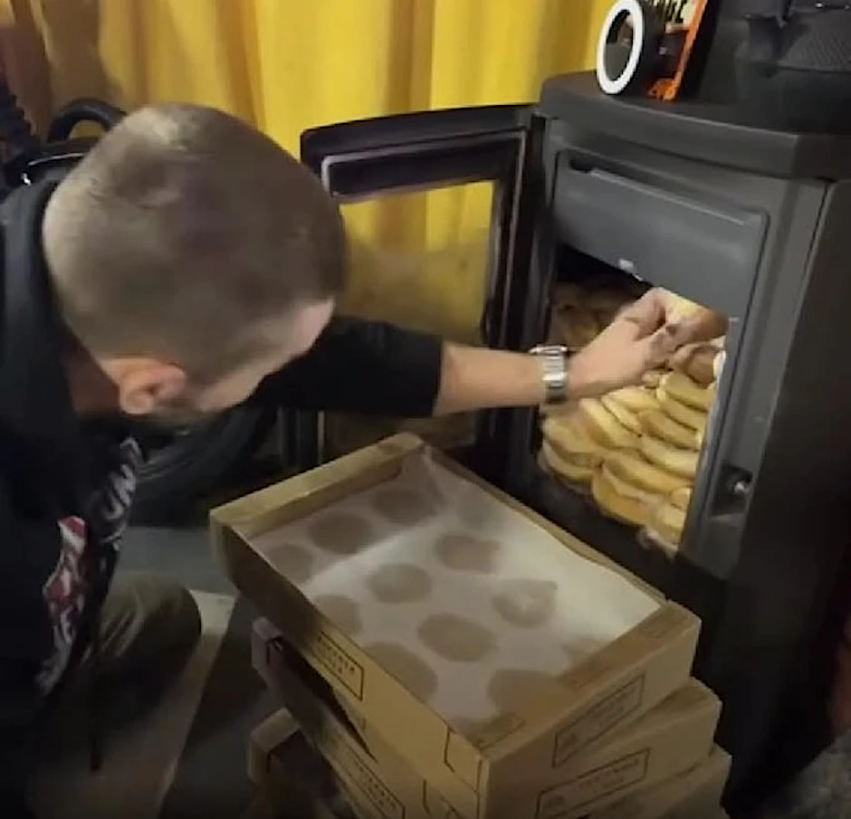 Marek Hoffmann stopft dutzende Pfannkuchen in seinen gusseisernen Ofen.