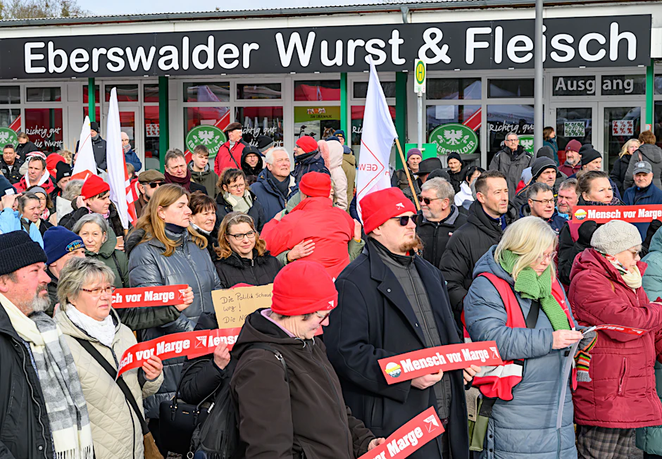 Viele Beschäftigte nehmen mit Protestschildern an der "Trauerfeier" für den Eberswalder Wurst-Traditionsbetrieb teil. 