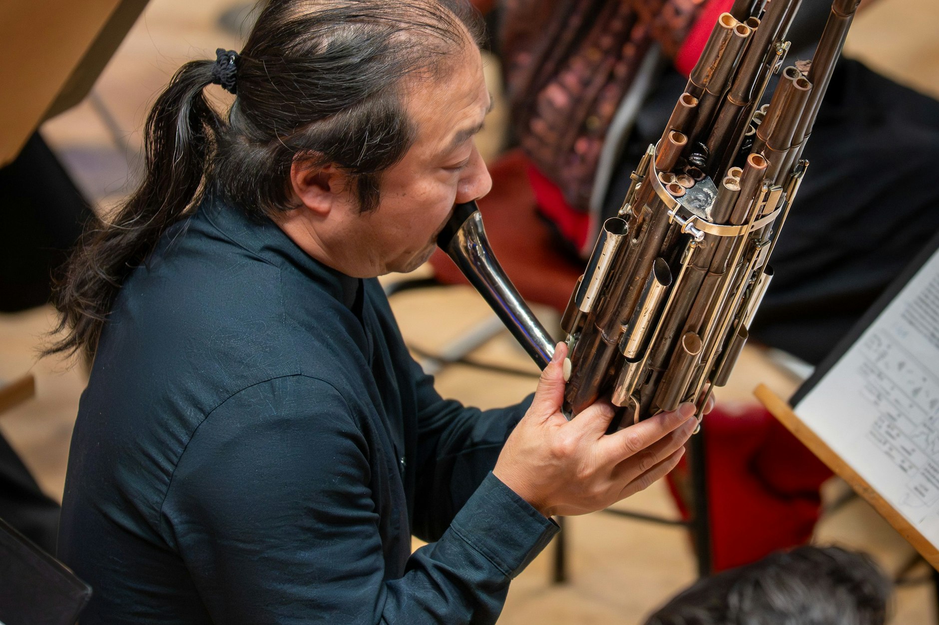 Ein Musiker des Orchesters mit einer chinesischen Sheng