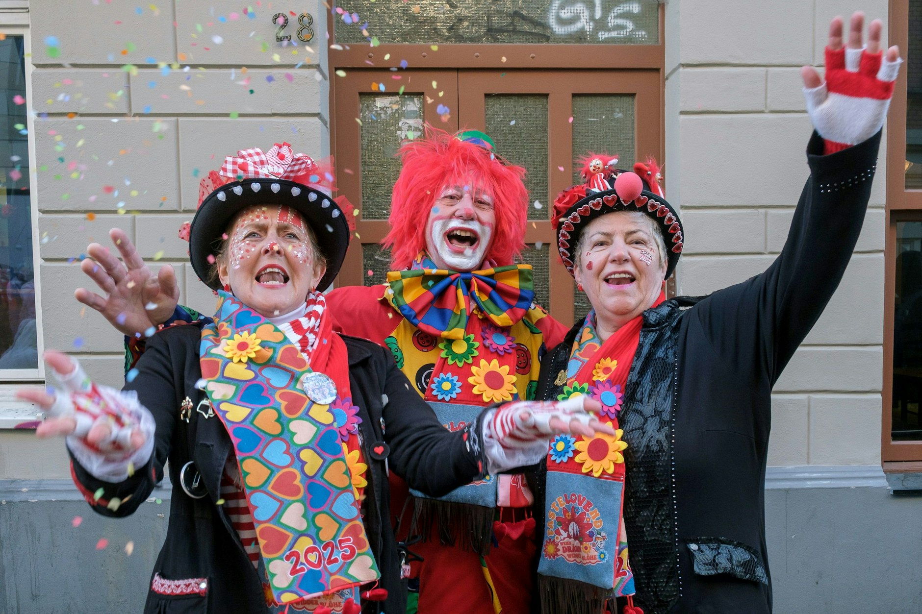 Drei Jecken beim Rosenmontagszug in Köln 2025. 