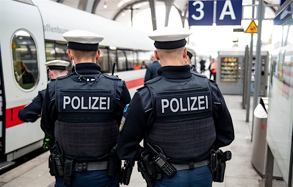 Bundespolizisten stehen vor der Abfahrt eines ICE an einem Gleis.