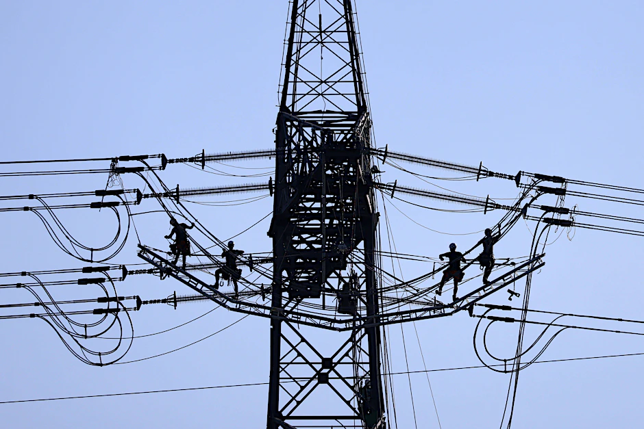 Monteure reparieren einen defekten Strommast (Symbolfoto).