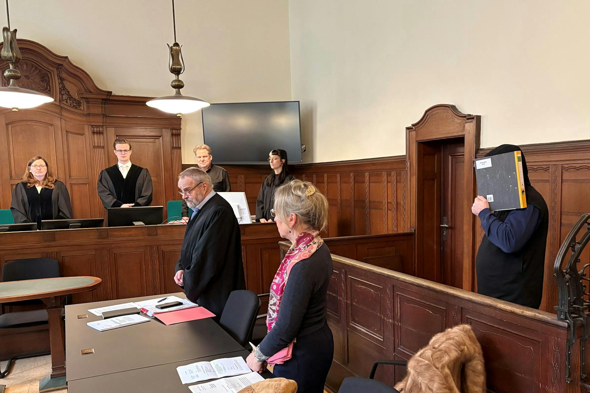 Girmantas B. (43, r.) versteckt vor Gericht sein Gesicht hinter einem Ordner.