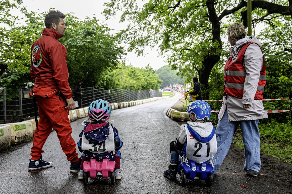 Kinder fahren 2024 in Hünxe in Nordrhein-Westfalen bei einem Rennen mit ihren Bobby-Cars einen Berg herunter. 