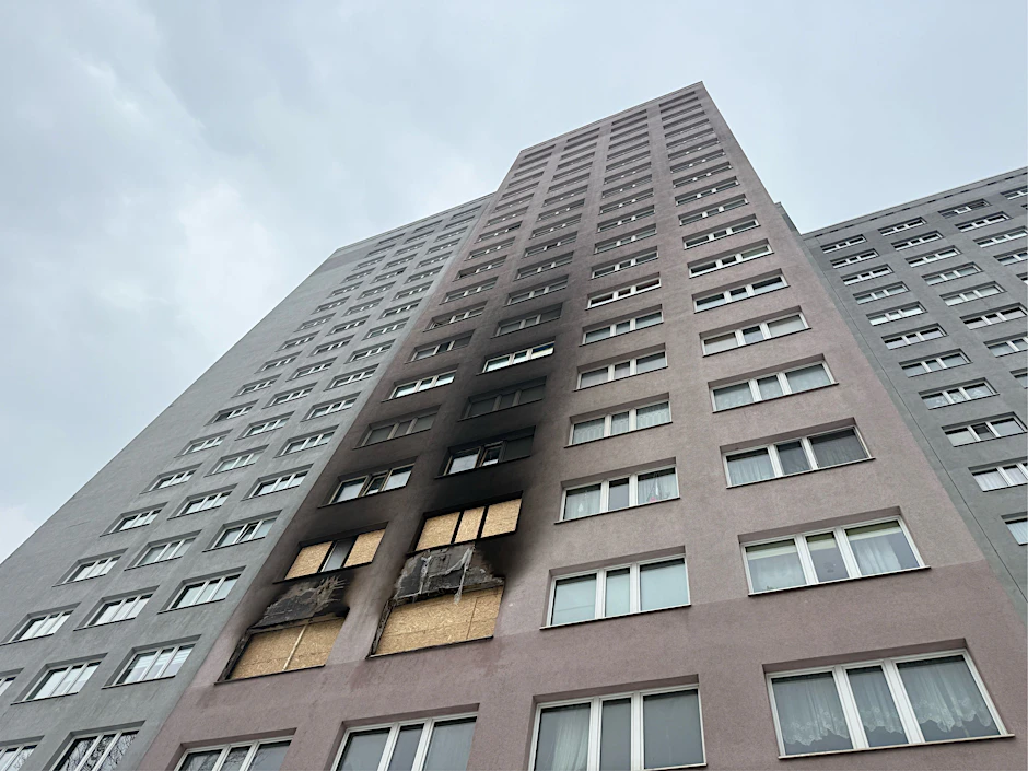 Das Hochhaus in Friedrichsfelde nach dem Brand. Die Feuerwehr ist vor Ort.