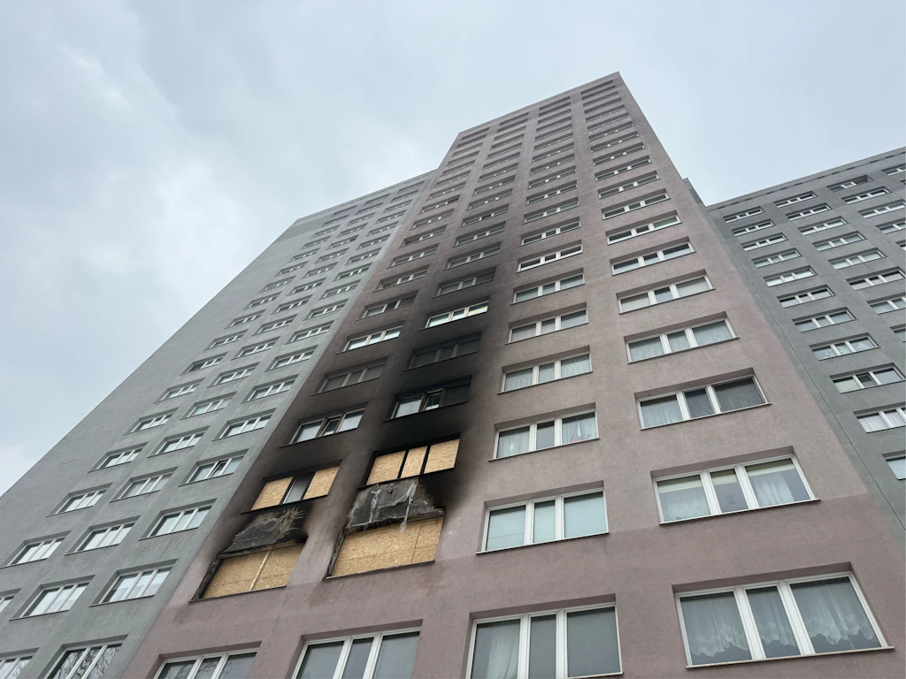 Das Hochhaus in Friedrichsfelde nach dem Brand. Die Feuerwehr ist vor Ort.