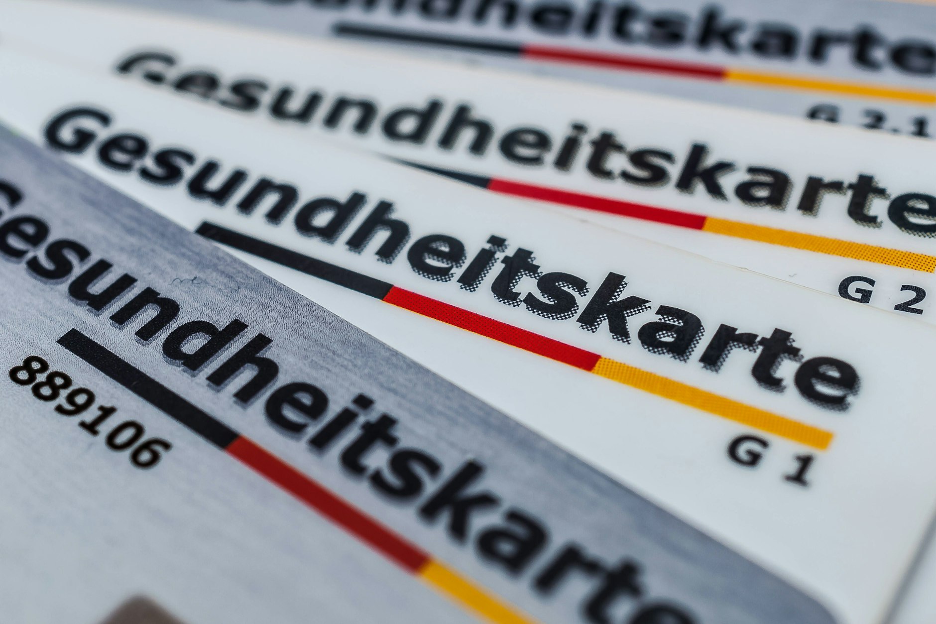 Gesundheitskarten liegen aufgefächert auf einem Tisch.