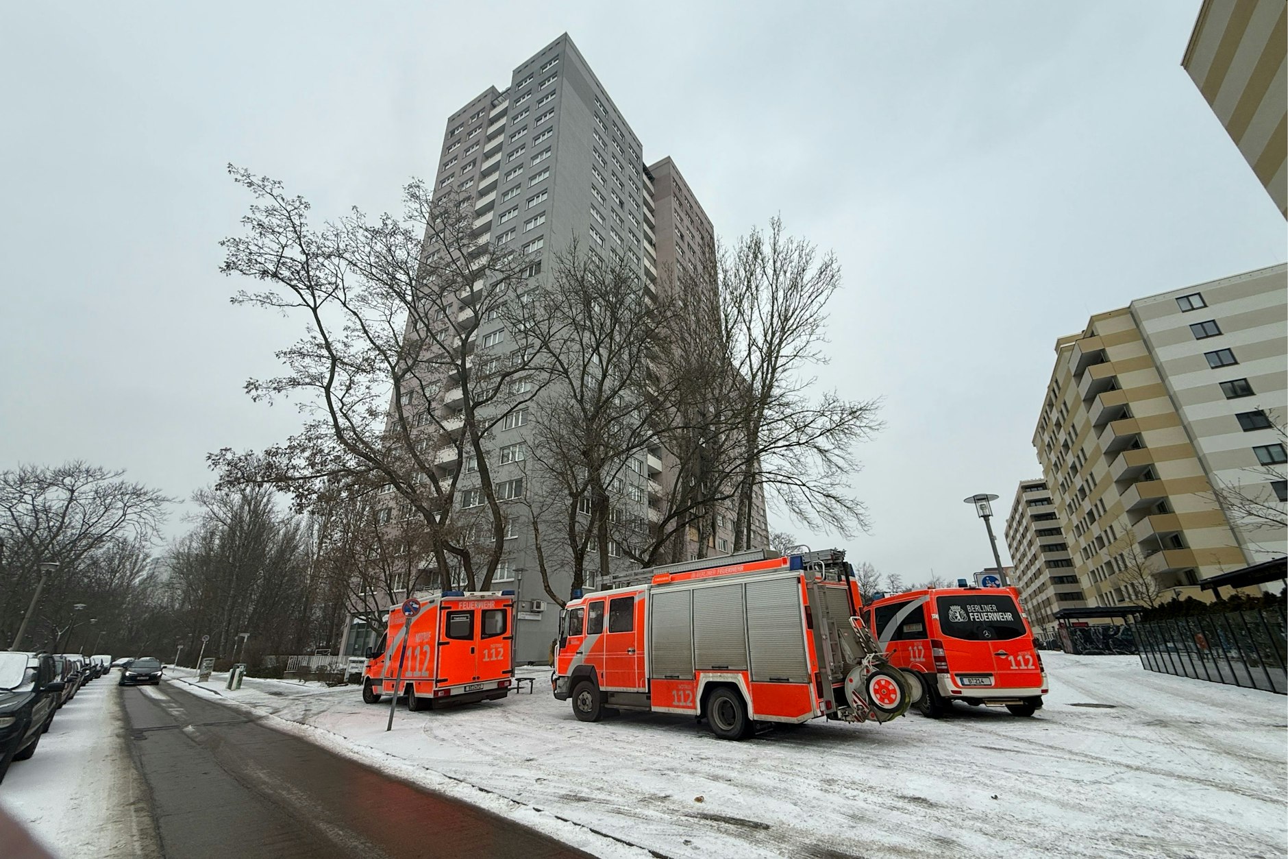 Das Hochhaus in Friedrichsfelde nach dem Brand. Die Feuerwehr ist vor Ort.