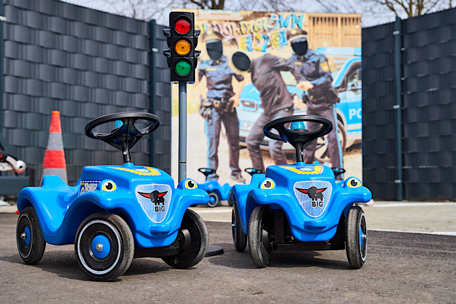 Zwei Bobby-Car-Sondermodelle stehen vor einer Kulisse der Kinderpolizeiwache in Augsburg (Symbolfoto).