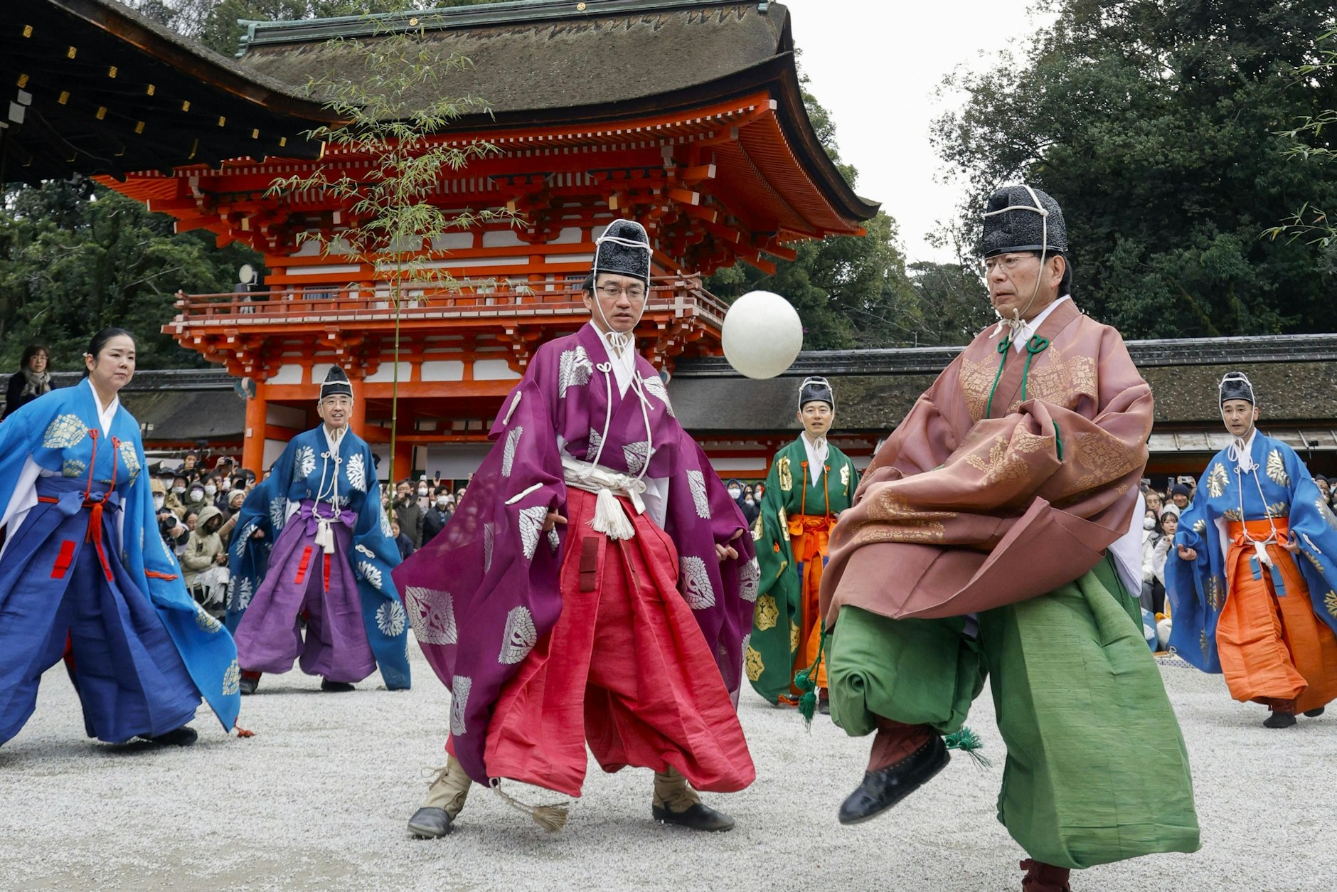 Touristenattratkion in Kyoto: Menschen in traditioneller Kleidung spielen am Shimogamo-Schrein „kemari“.