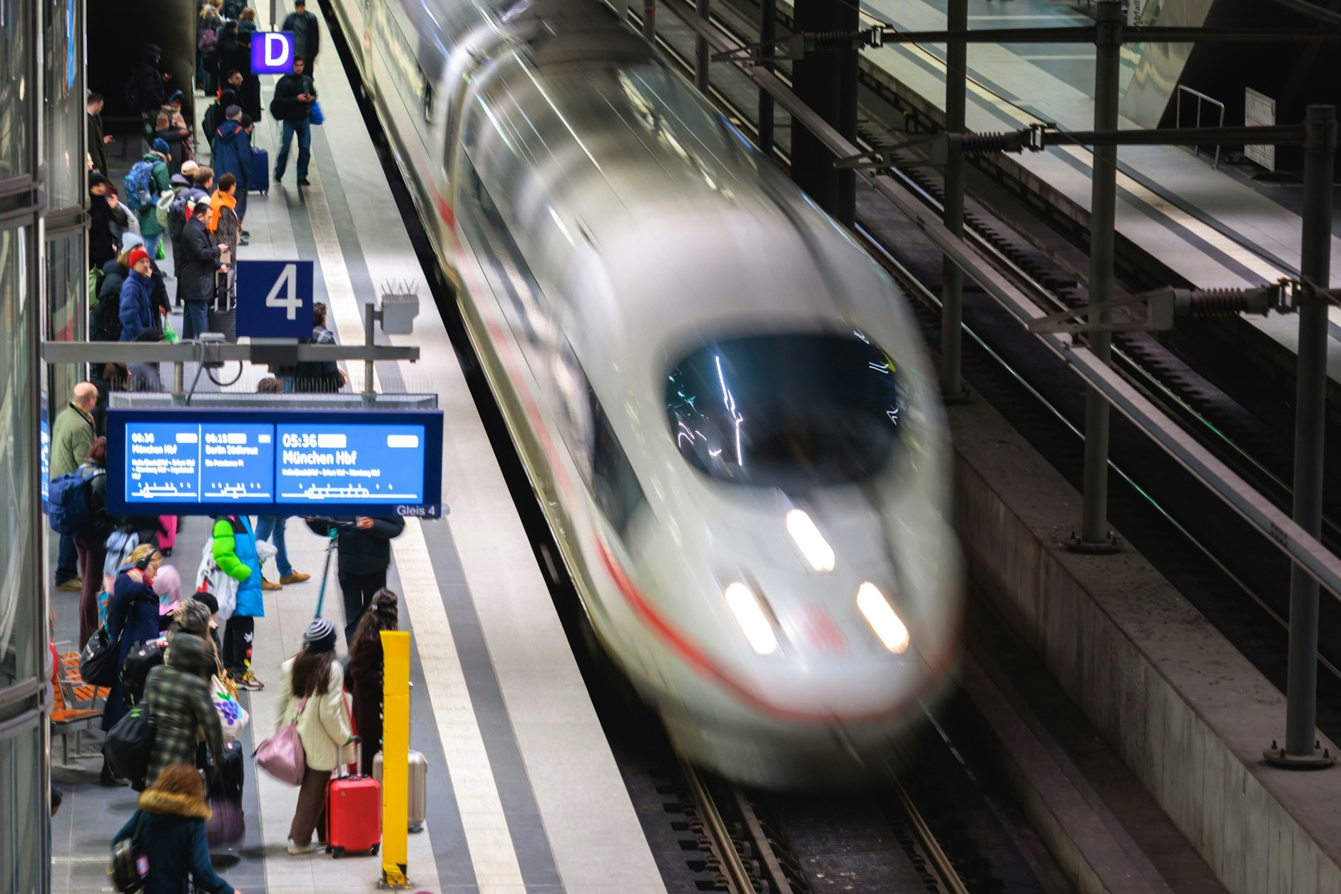 Zugreisende warten im Berliner Hauptbahnhof auf einen ICE.