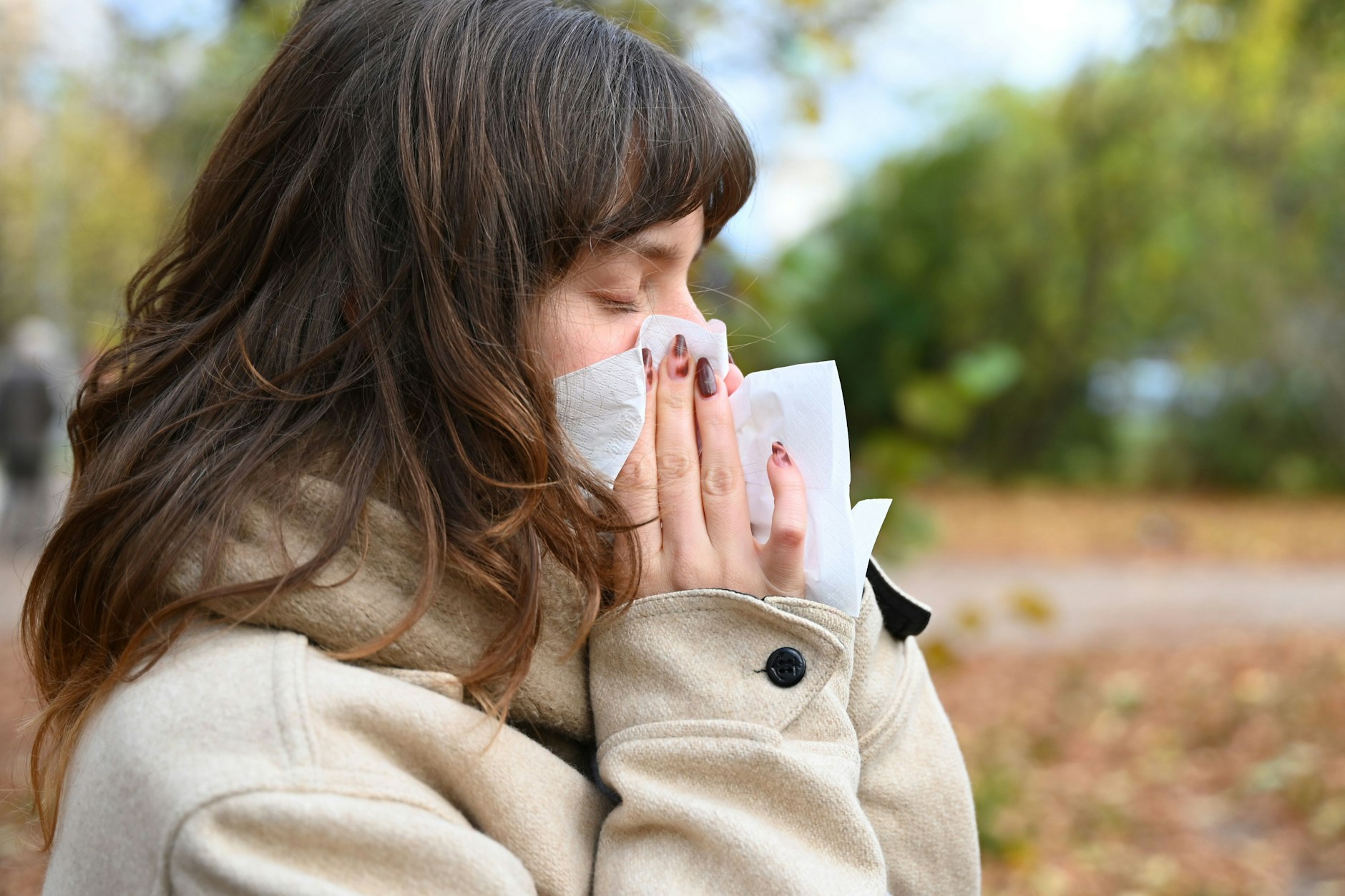 Eine Frau schnäuzt in ein Taschentuch: Pneumokokken werden über Nasensekret übertragen.