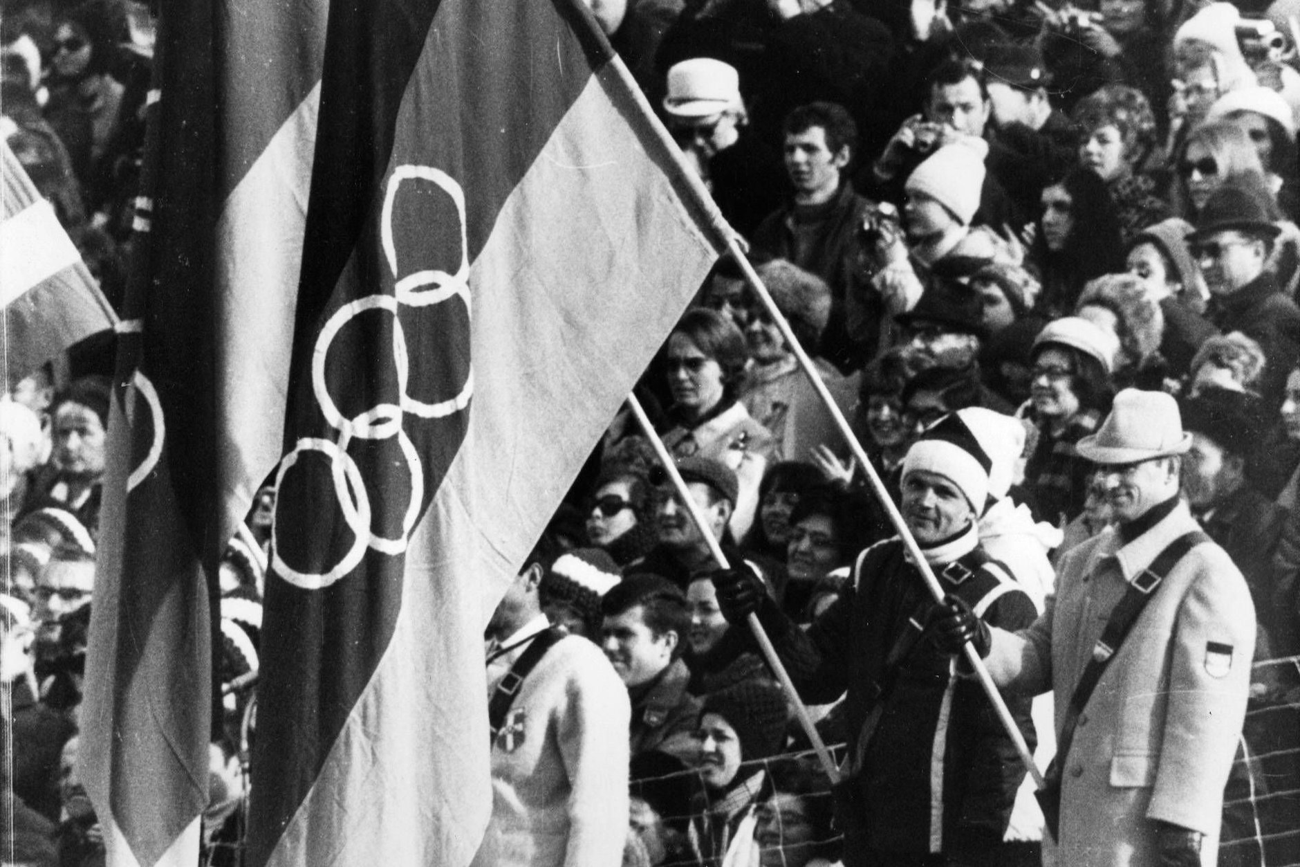 Bei den Olympischen Winterspielen 1968 in Grenoble treten erstmals die Bundesrepublik Deutschland und die DDR mit einem eigenen Team an. Fahnenträger sind die Rodler Hans Plenk (links/BRD) und Thomas Köhler (DDR).
