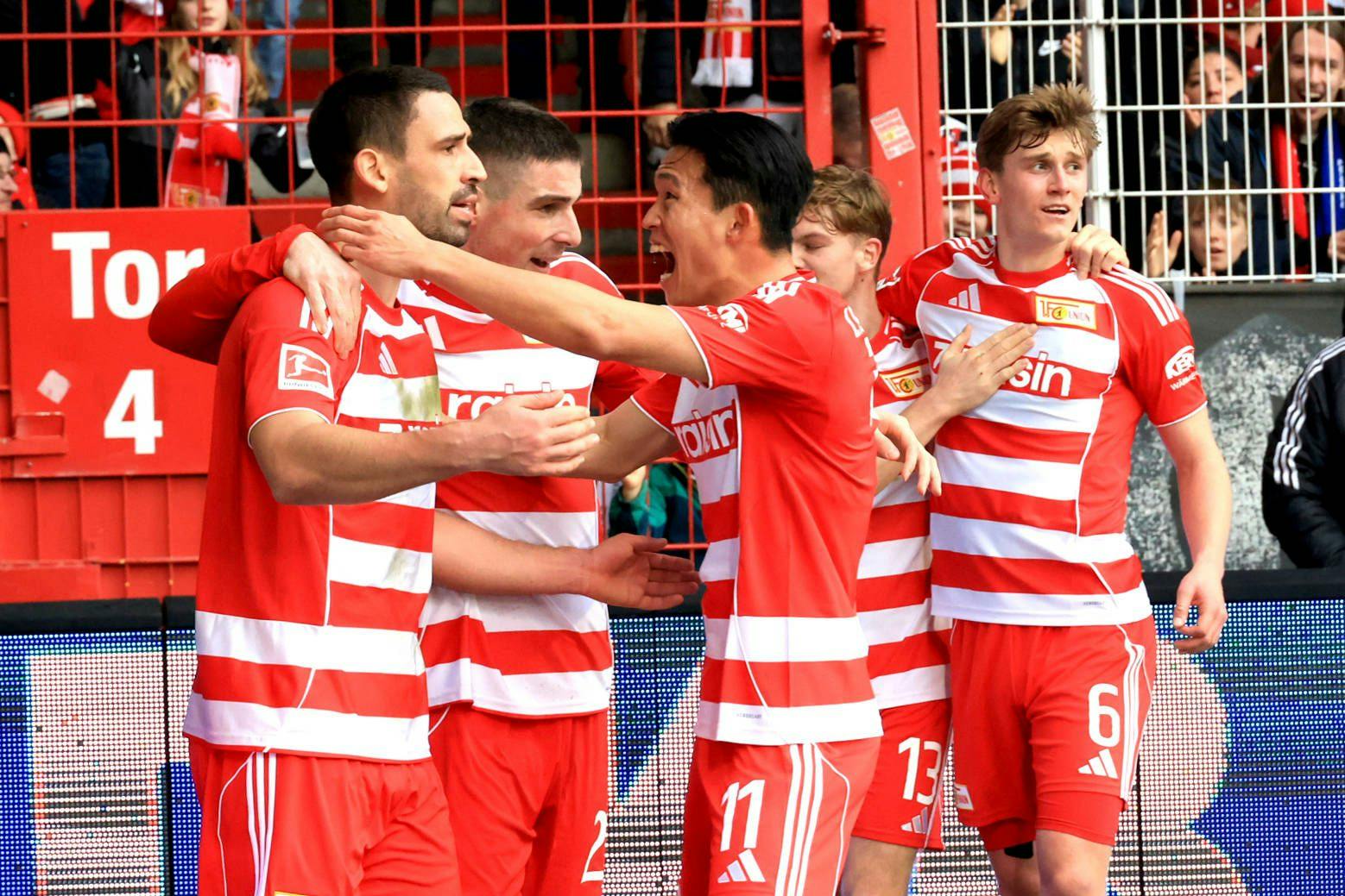 Rani Khedira (l.) hat gerade für den 1. FC Union Berlin getroffen. Seine Mitspieler jubeln mit ihm.