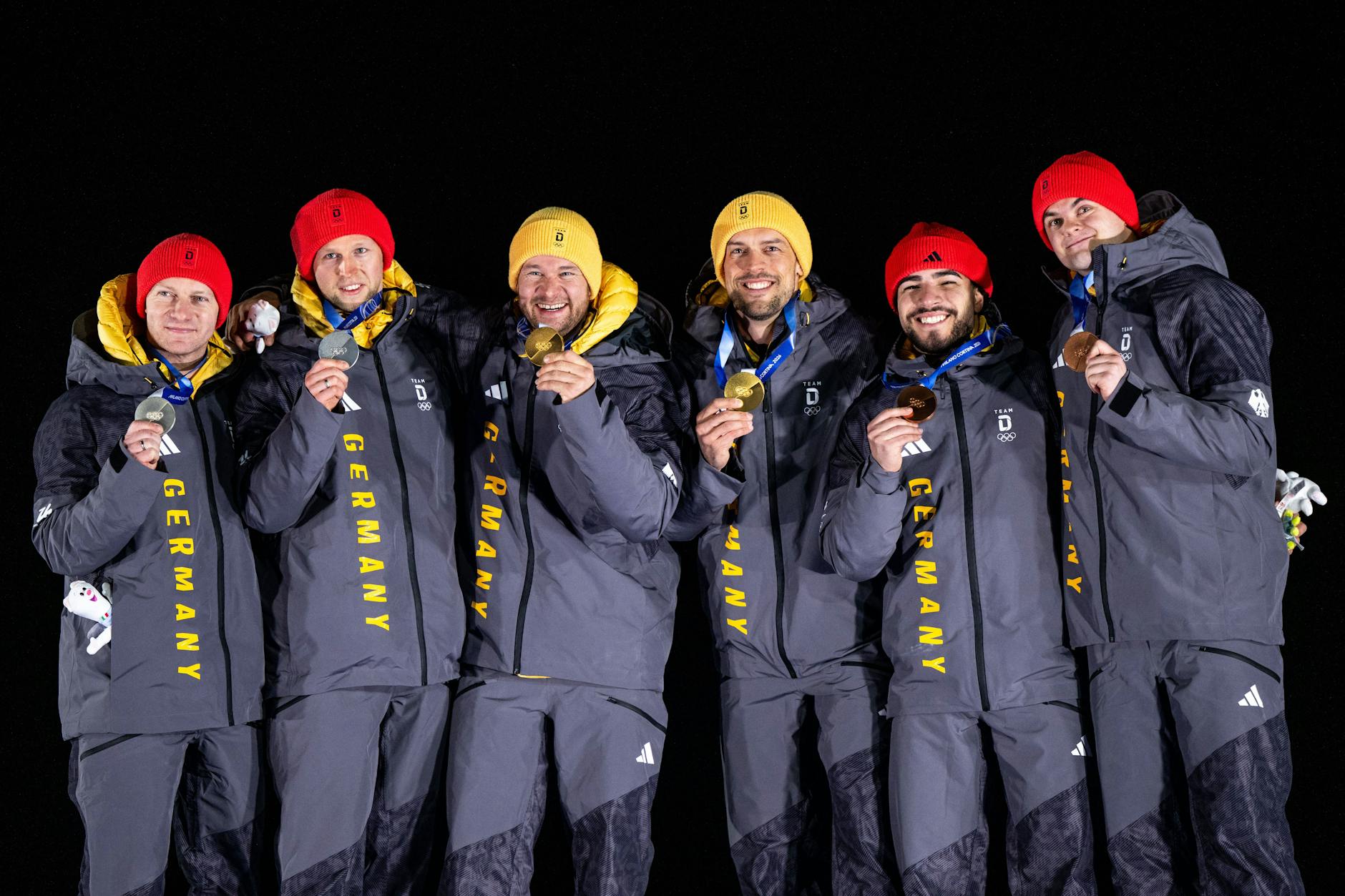Die deutschen Zweierbob-Teams der Herren jubeln bei den Olympischen Winterspielen 2026 über die Gold-, Silber- und Bronzemedaille.