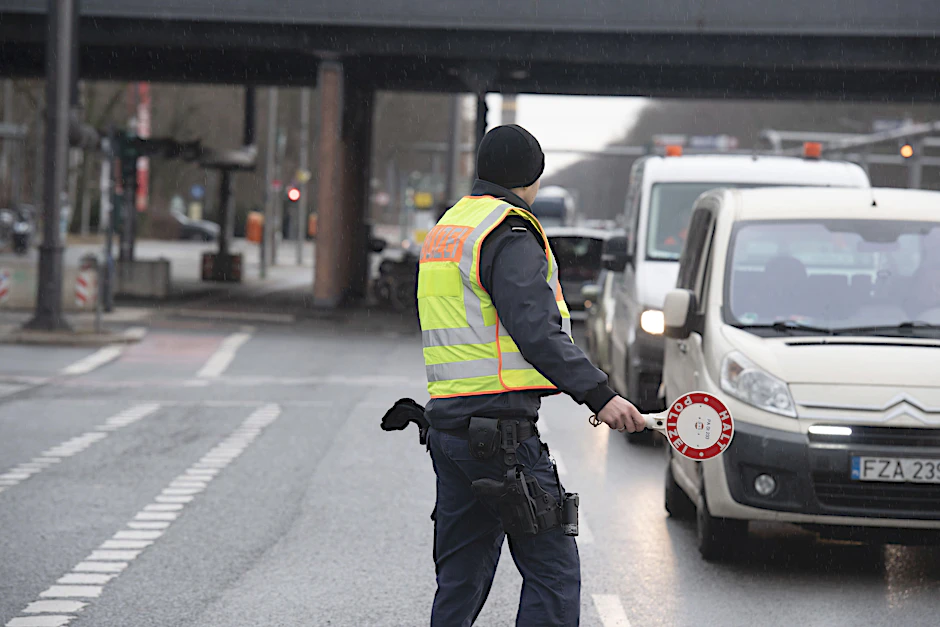 Ein Polizist stoppt am Montagmorgen auf der Straße des 17. Juni ein Auto.