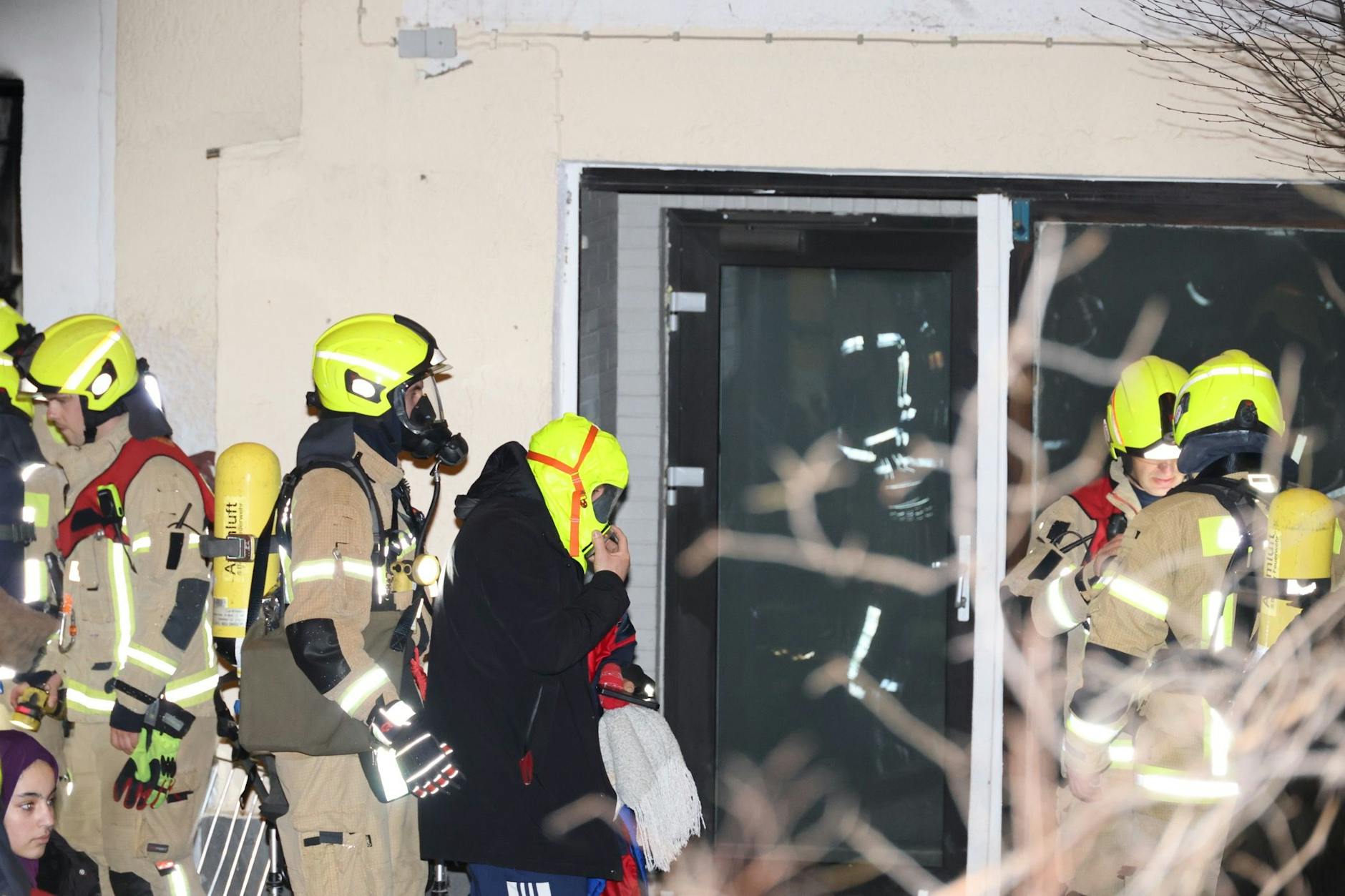 Hier trägt ein Hausbewohner (mittig) die sogenannte Brandschutzhaube.