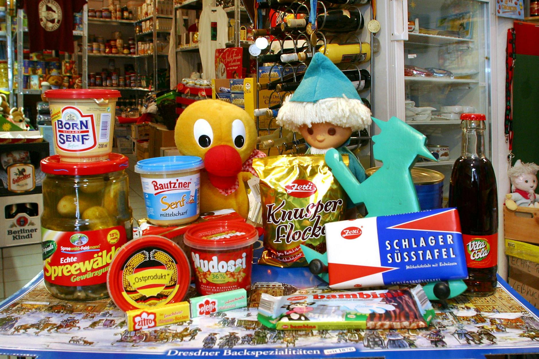 Viele Produkte aus dem Osten sind noch heute beliebt. Dazu gehören auch die Knusperflocken aus dem Osten – hier in der Mitte des bunten Tisches mit Klassikern aus dem Supermarkt.