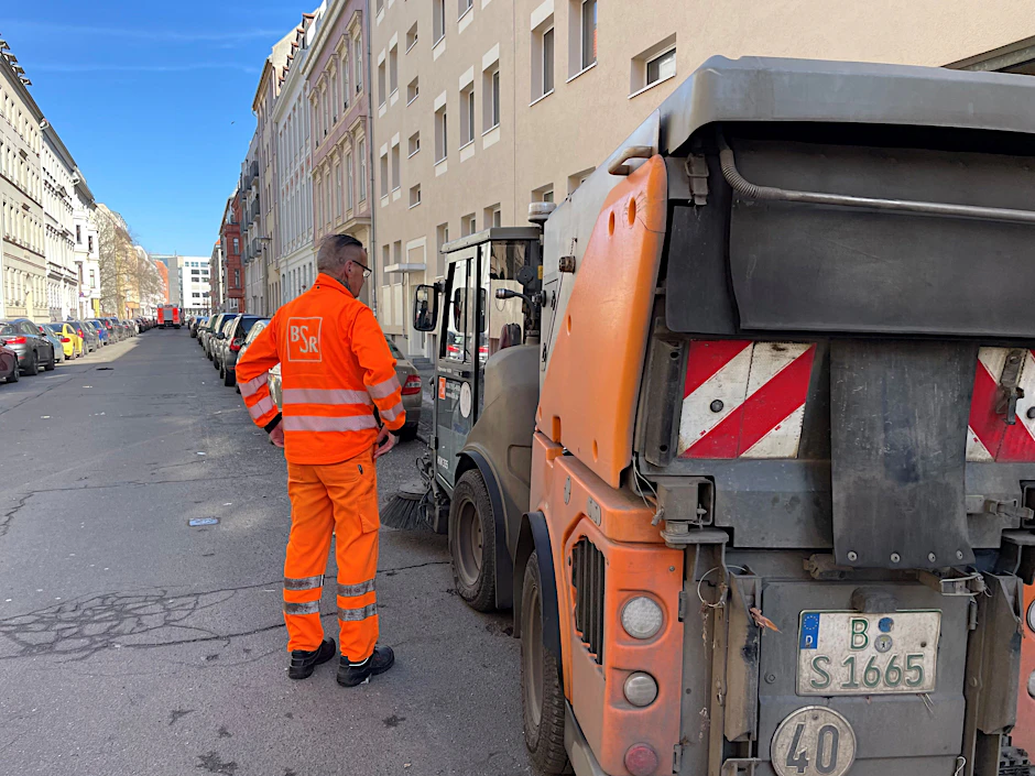 Der Fahrer der BSR-Kehrmaschine in der Almstadtstraße steht neben seinem Fahrzeug. Ihm ist zum Glück nichts passiert.