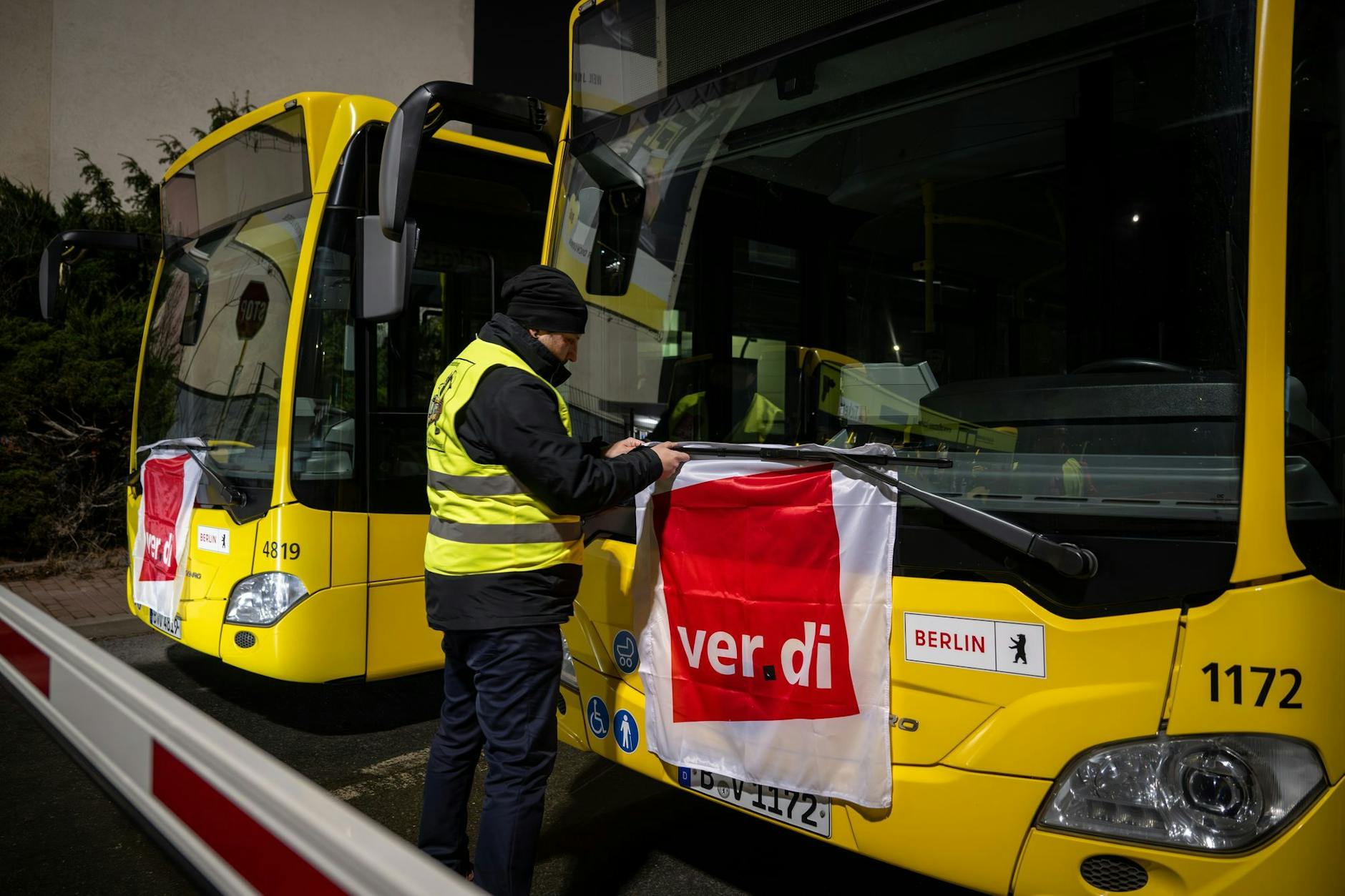Straßenbahnfahrer Manuel von Stubenrauch befestigt während eines Warnstreiks bei der BVG eine Verdi-Fahne an einem Bus.