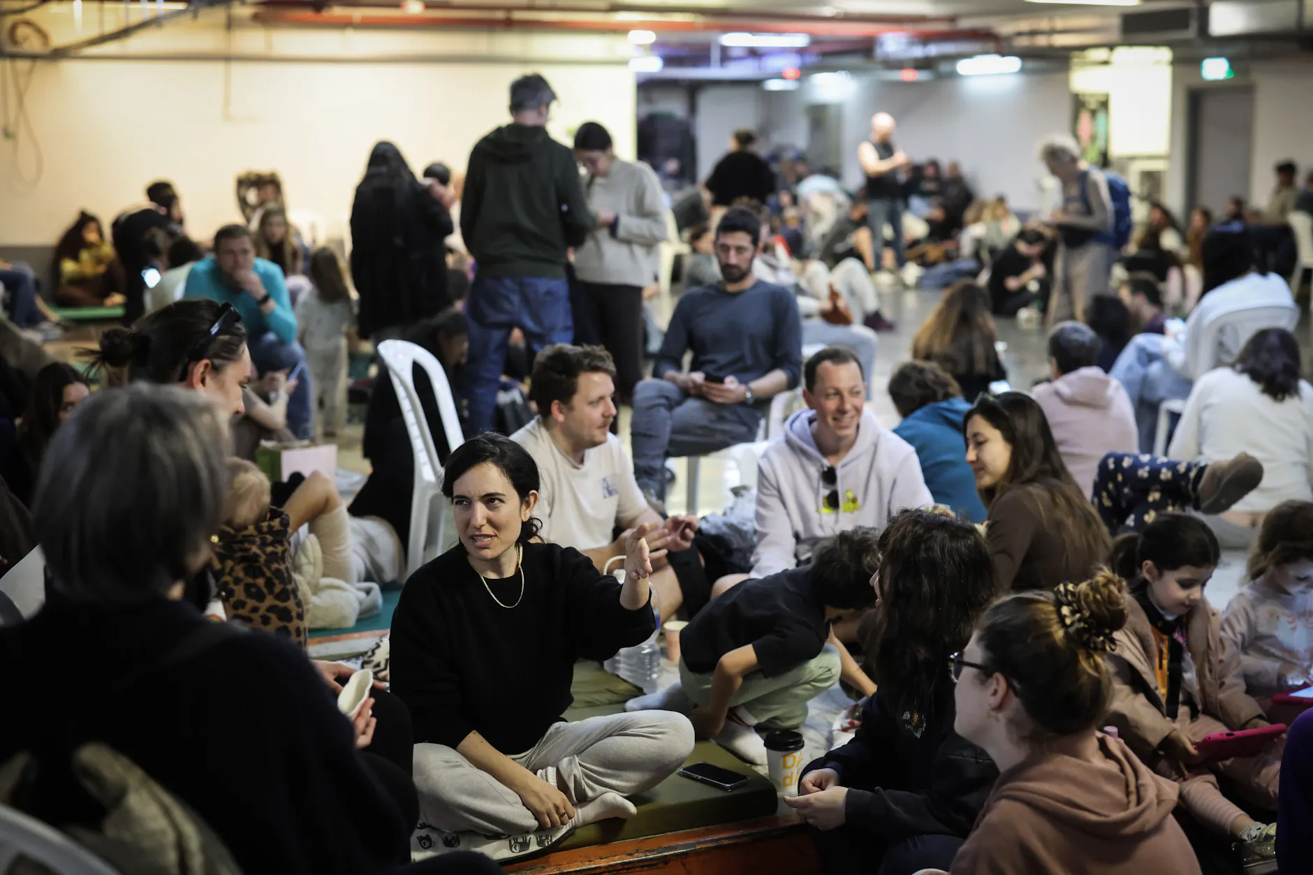 Menschen suchen in Tel Aviv Schutz in einer Tiefgarage, nachdem Alarm wegen ankommender Raketen aus dem Iran ausgelöst wurde.