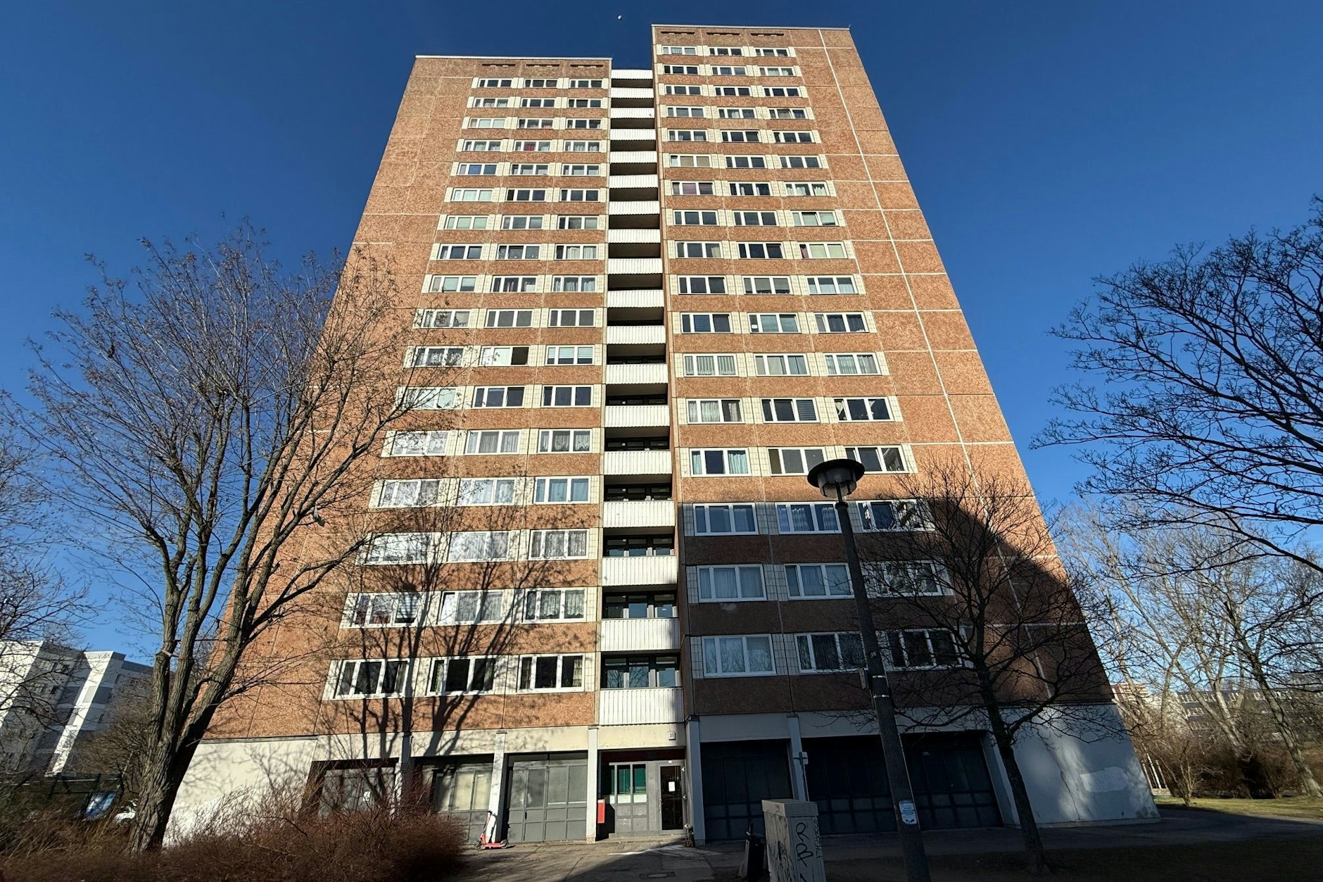 Neben dem Eingang zum Hochhaus haben Nachbarn Blumen abgelegt.