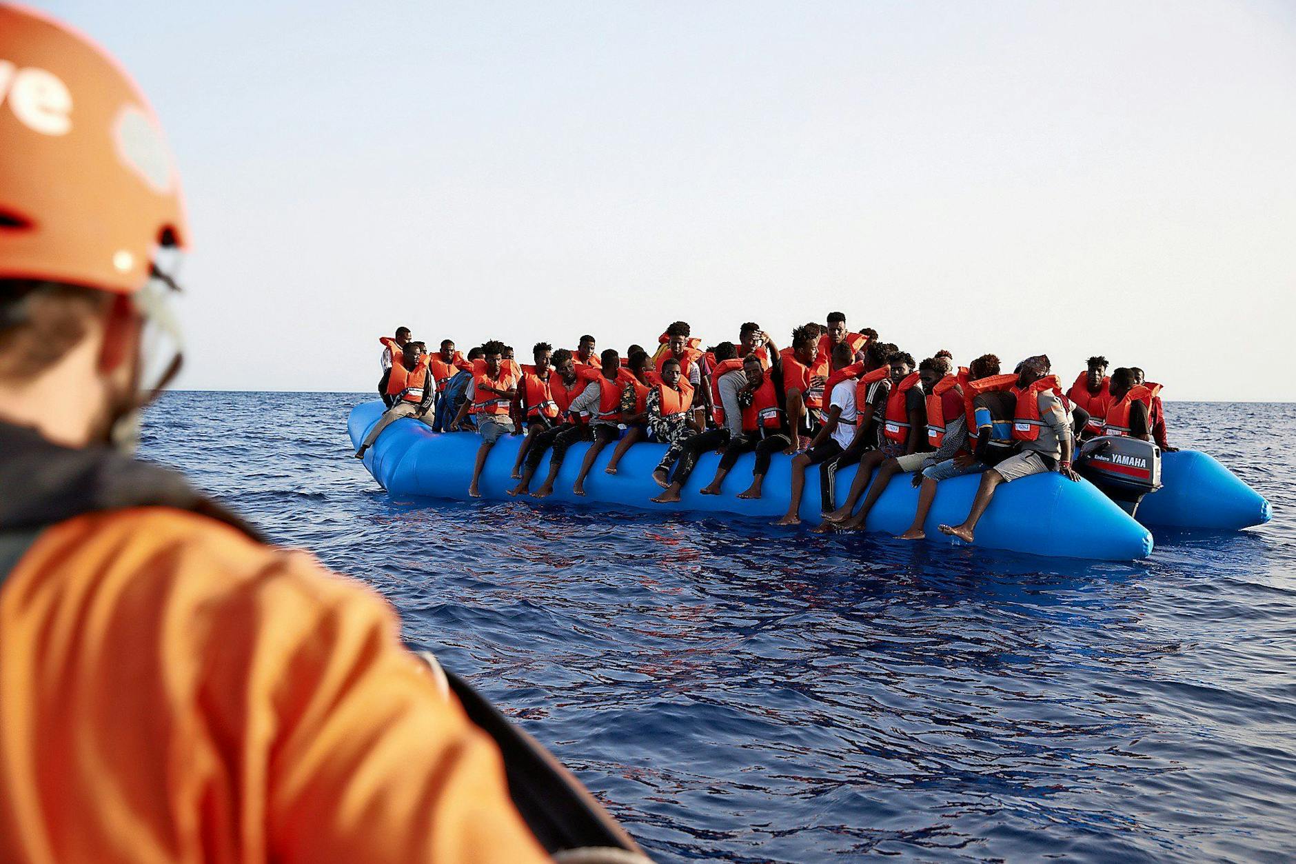 Migranten treiben in einem Boot im Mittelmeer