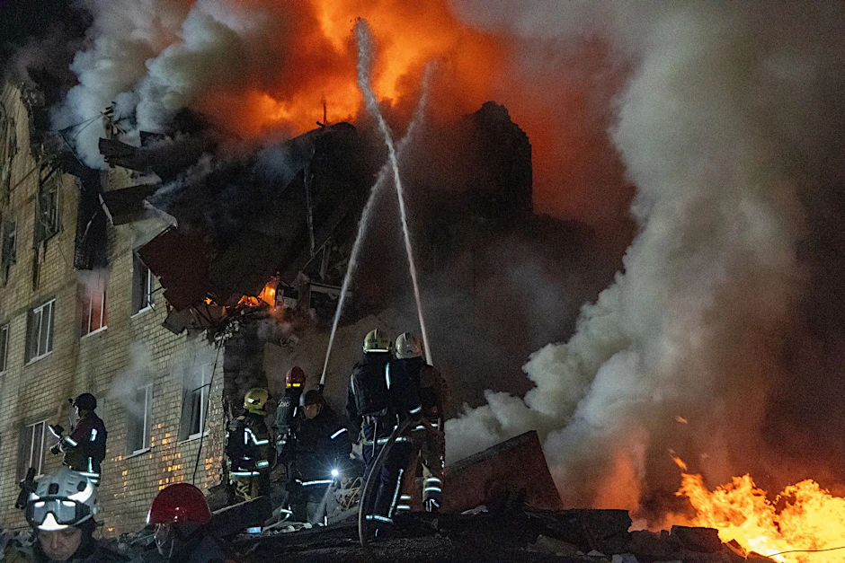 Feuerwehrleute bekämpfen einen Brand in einem Mehrfamilienhaus nach einem russischen Raketenangriff in Charkiw.