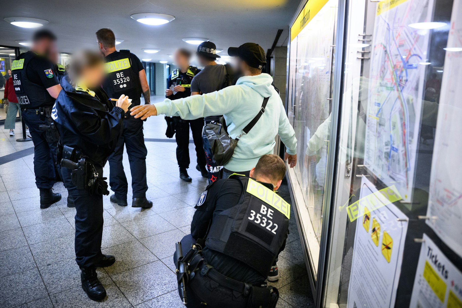 Polizeibeamte kontrollieren im U-Bahnhof Alexanderplatz junge Männer auf der Siche nach verbotenen Waffen.