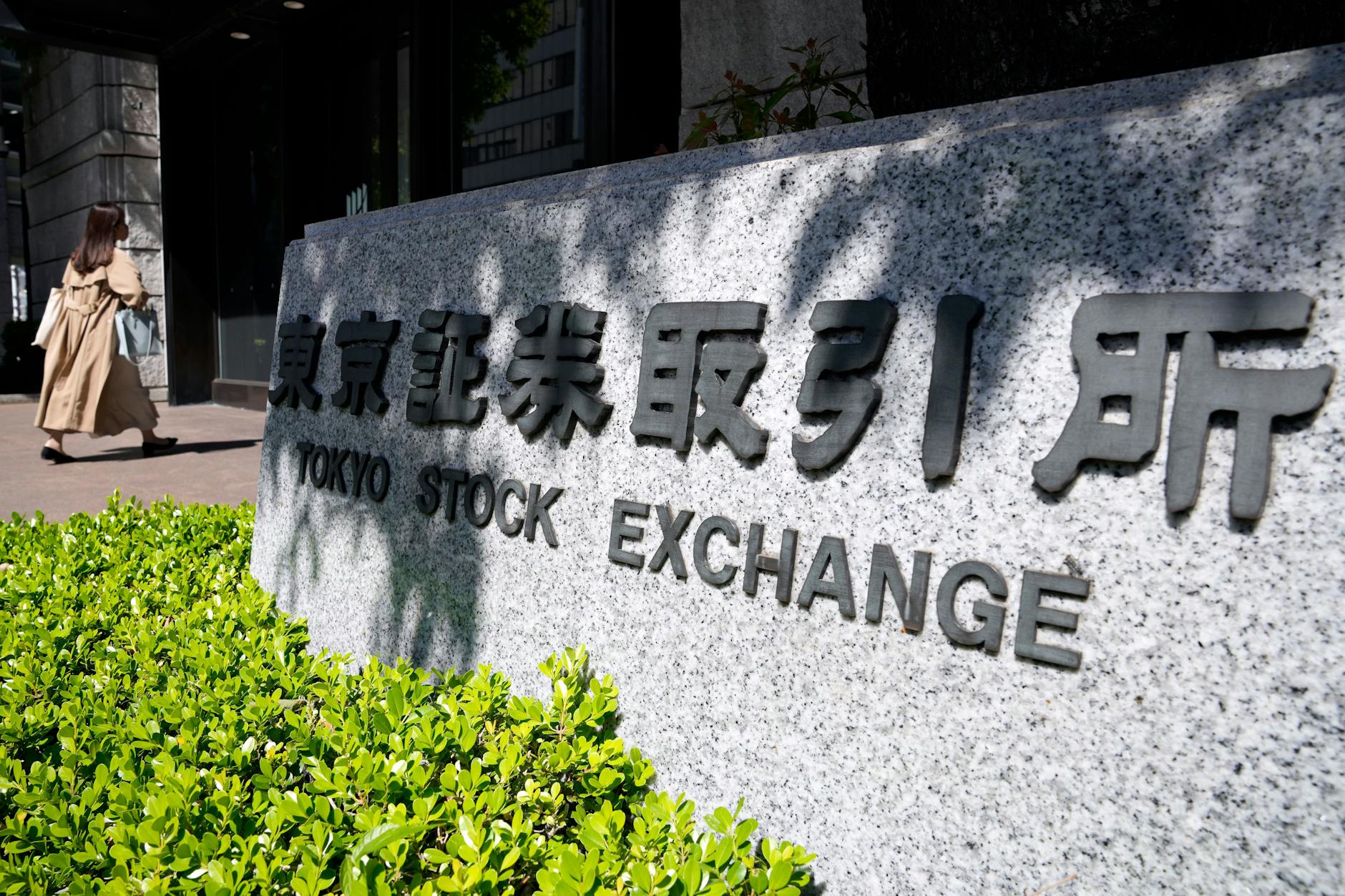 Eine Person geht in Tokio zum Gebäude der Tokioter Börse.