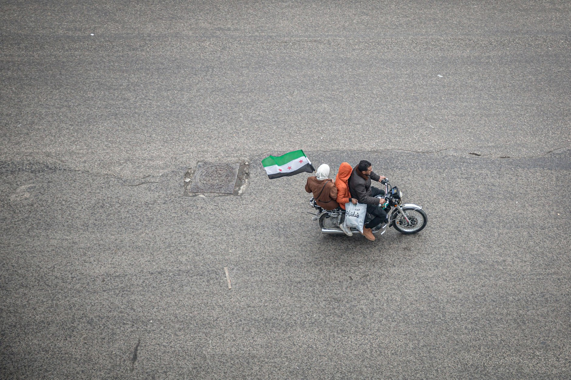 Im Dezember 2024 feiert eine Familie auf einem Mofa mit wehender Fahne den Sturz von Bashar al-Assad.