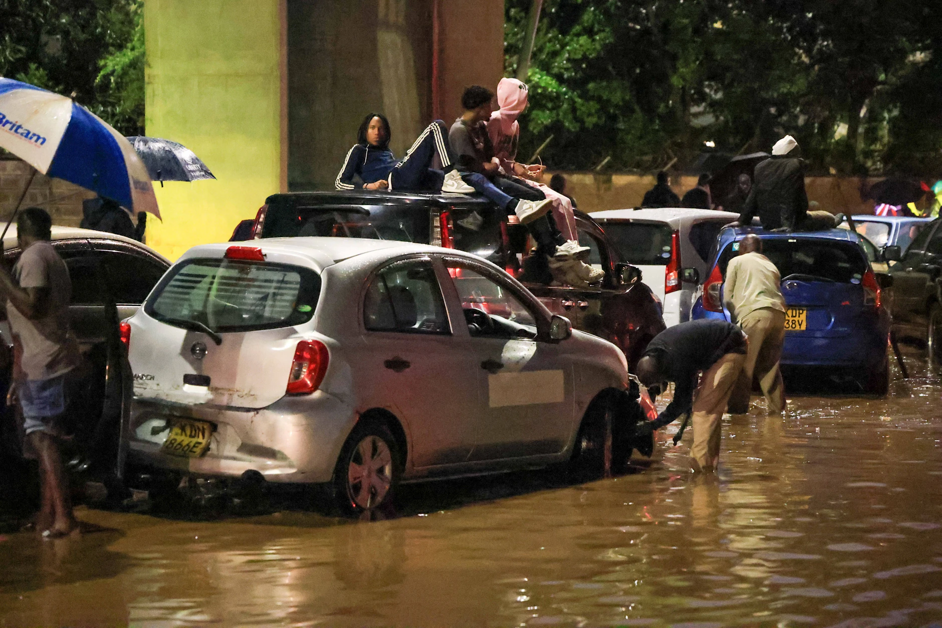 Menschen klettern auf ihre Autos, nachdem schwere Regenfälle die Straßen in Nairobi überflutet haben.