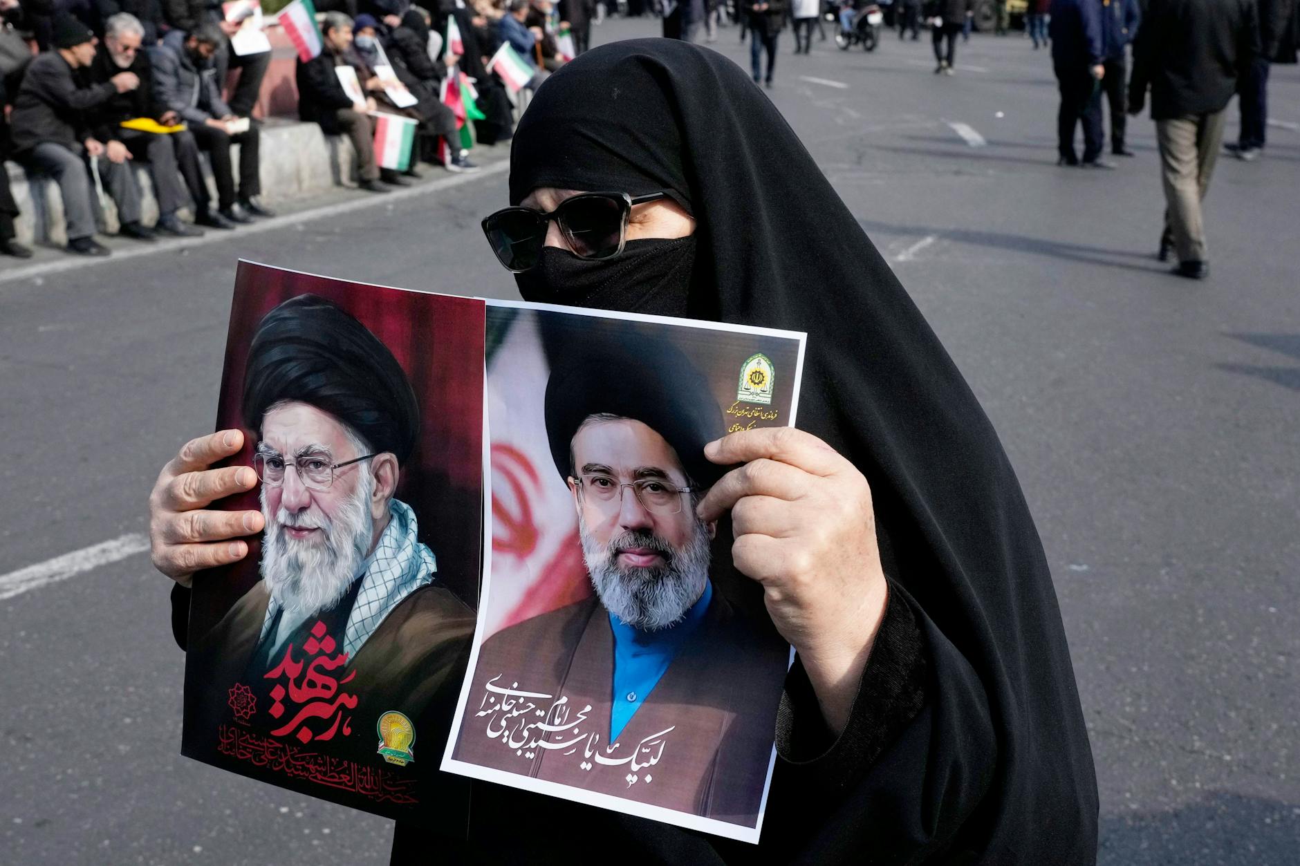 Eine Anhängerin der Islamischen Republik hält in Teheran Fotos des getöteten Obersten Führers Ali Chamenei und seines Sohnes und Nachfolgers Modschtaba Chamenei in die Höhe.