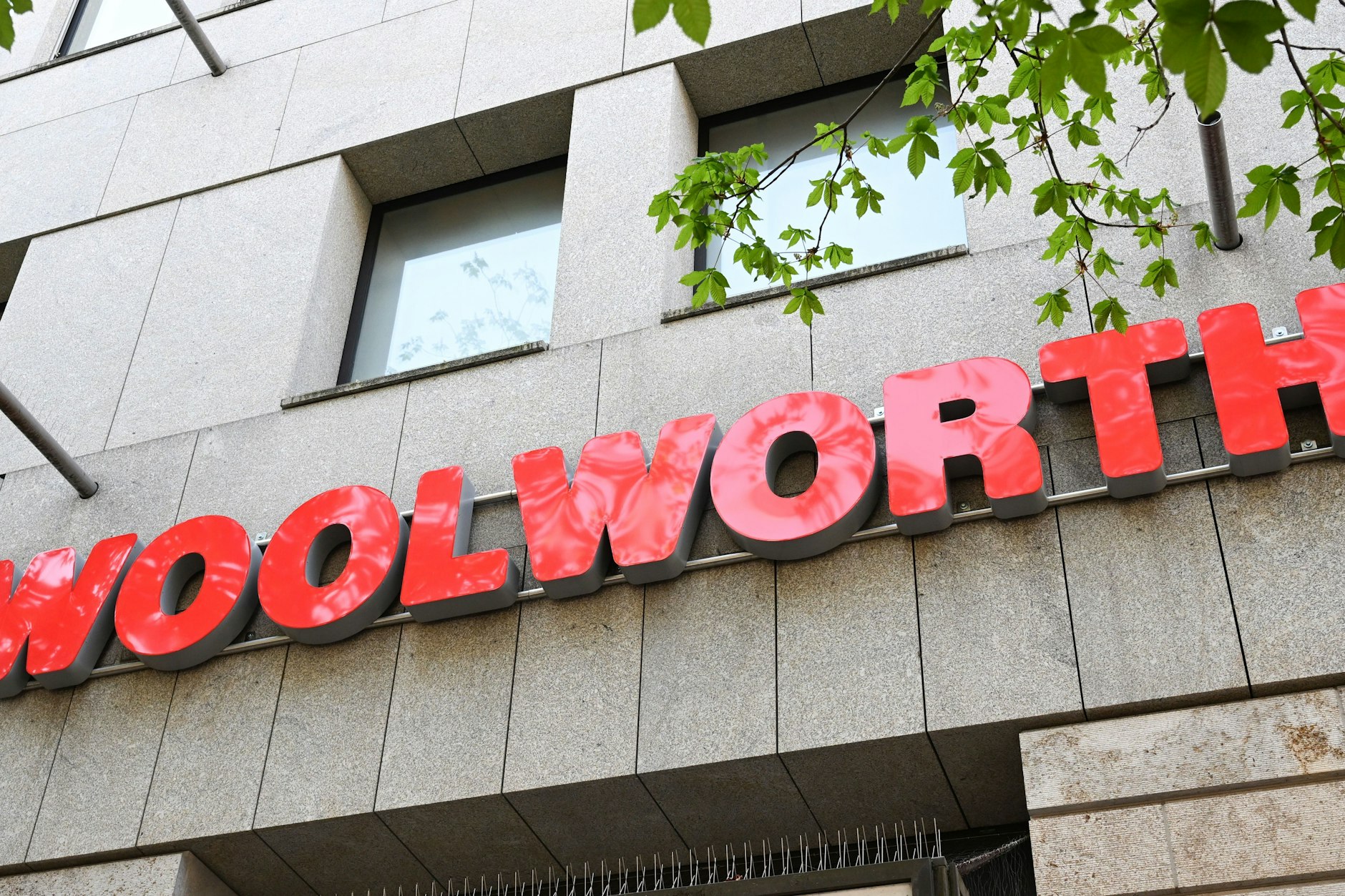 Das Logo der Handelskette Woolworth über dem Eingang eines Ladens.
